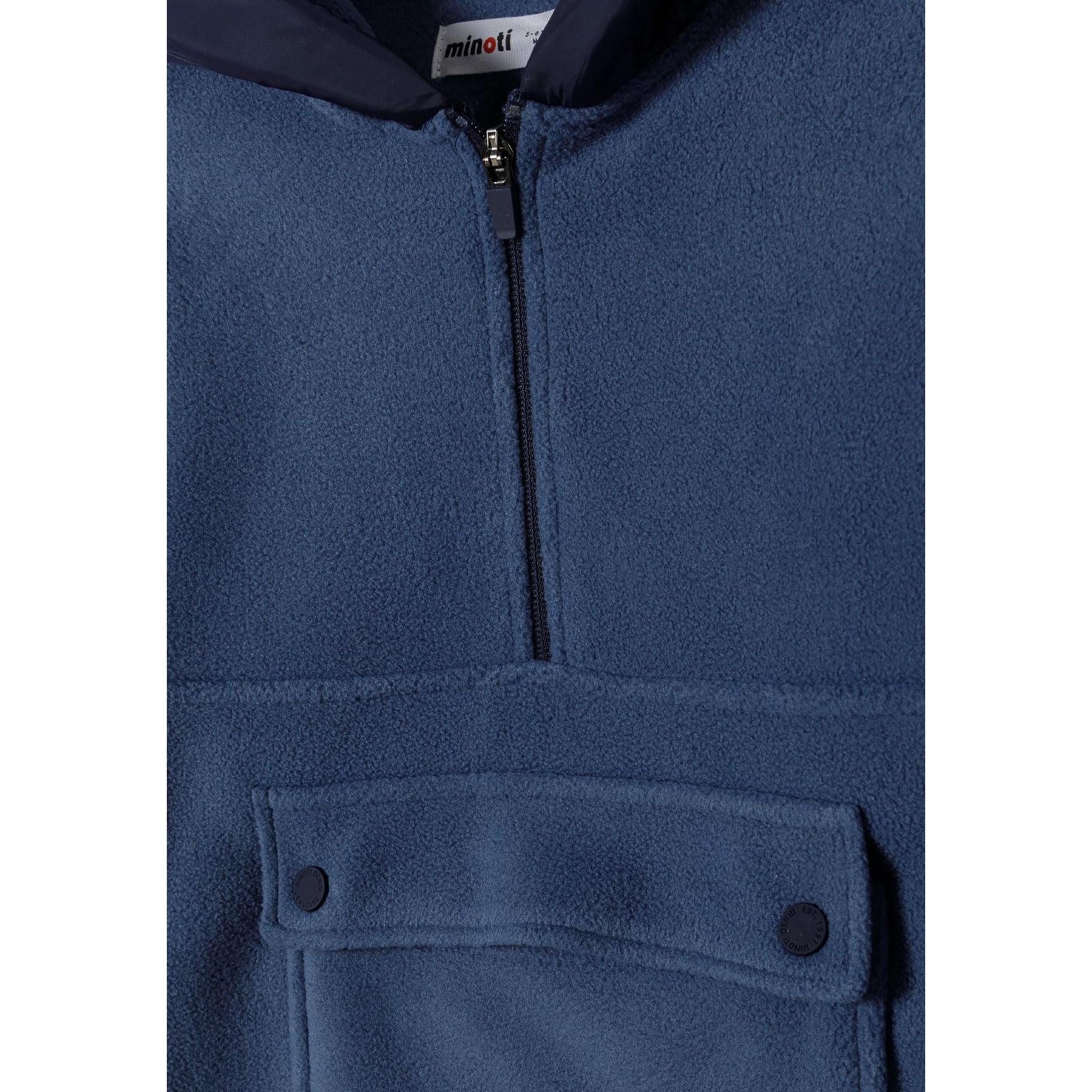 Close-up detail of blue microfleece hoodie showing Minoti label, half zip closure and front flap pocket with buttons