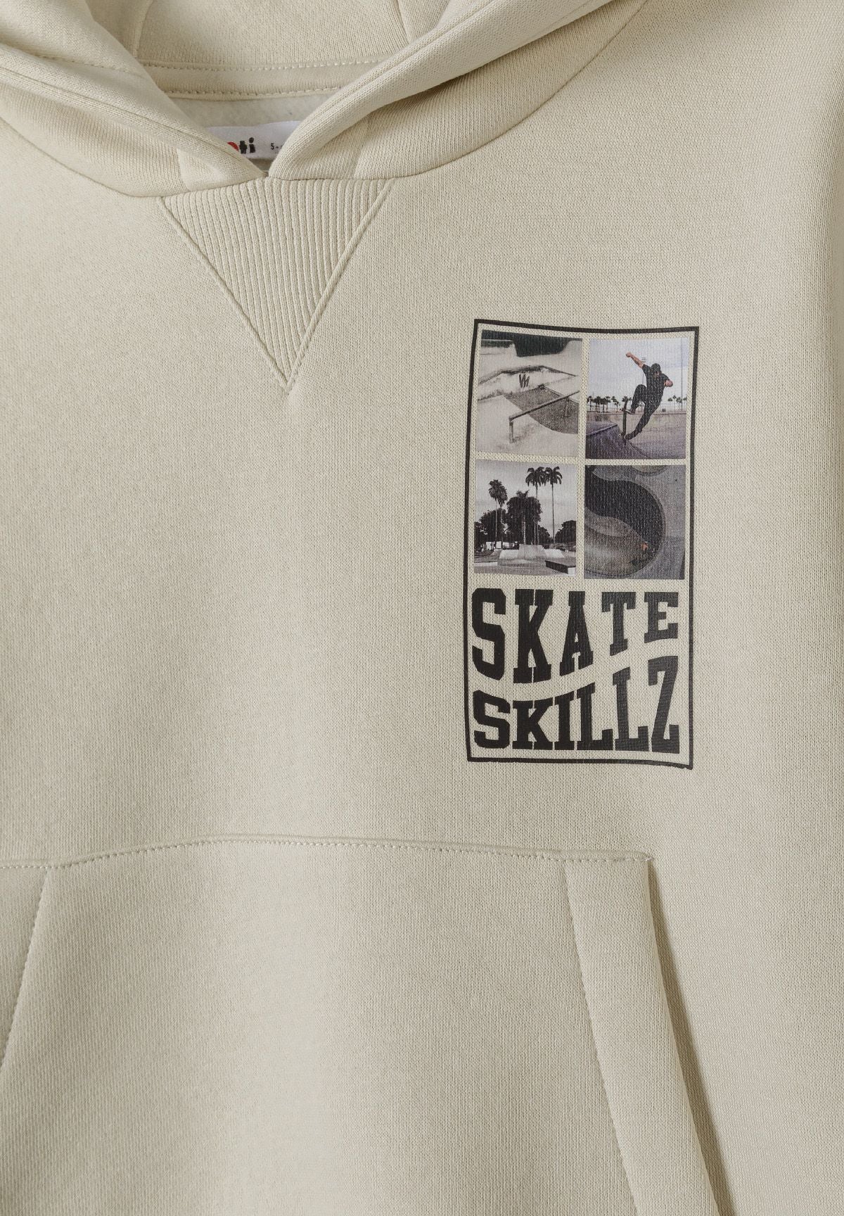 Close-up of Skate Skillz skateboarding collage above kangaroo pocket on stone hoodie.