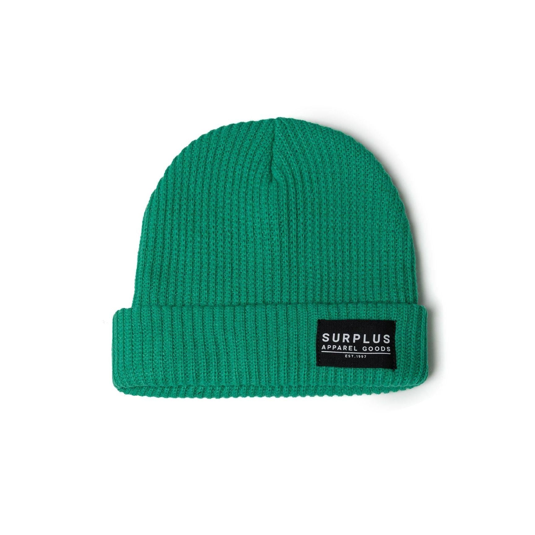 Close-up view of green ribbed knit beanie on white background showing texture and black woven label detail