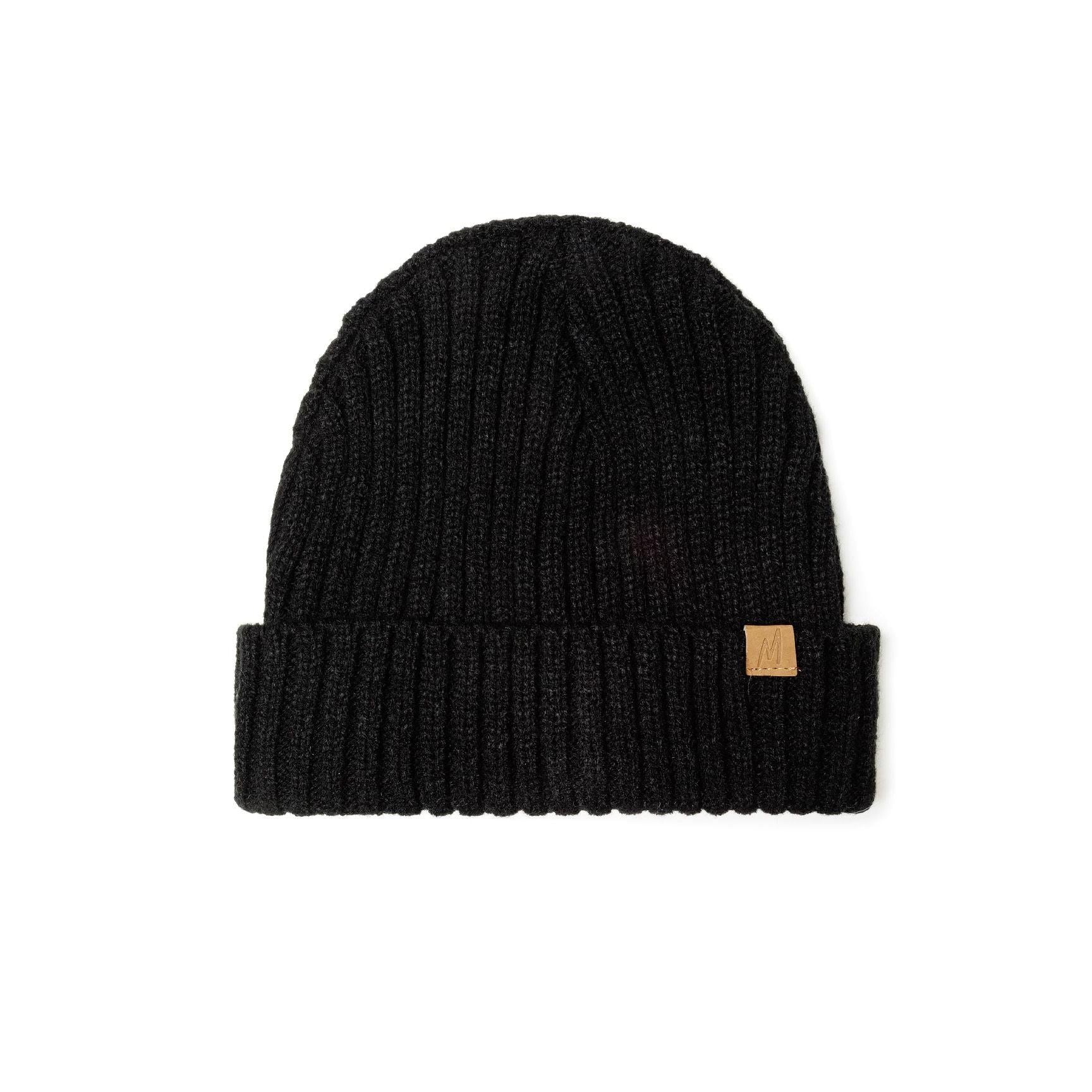 Black ribbed knit beanie displayed flat on white background showing ribbed texture pattern, folded cuff and brown leather-look tab detail