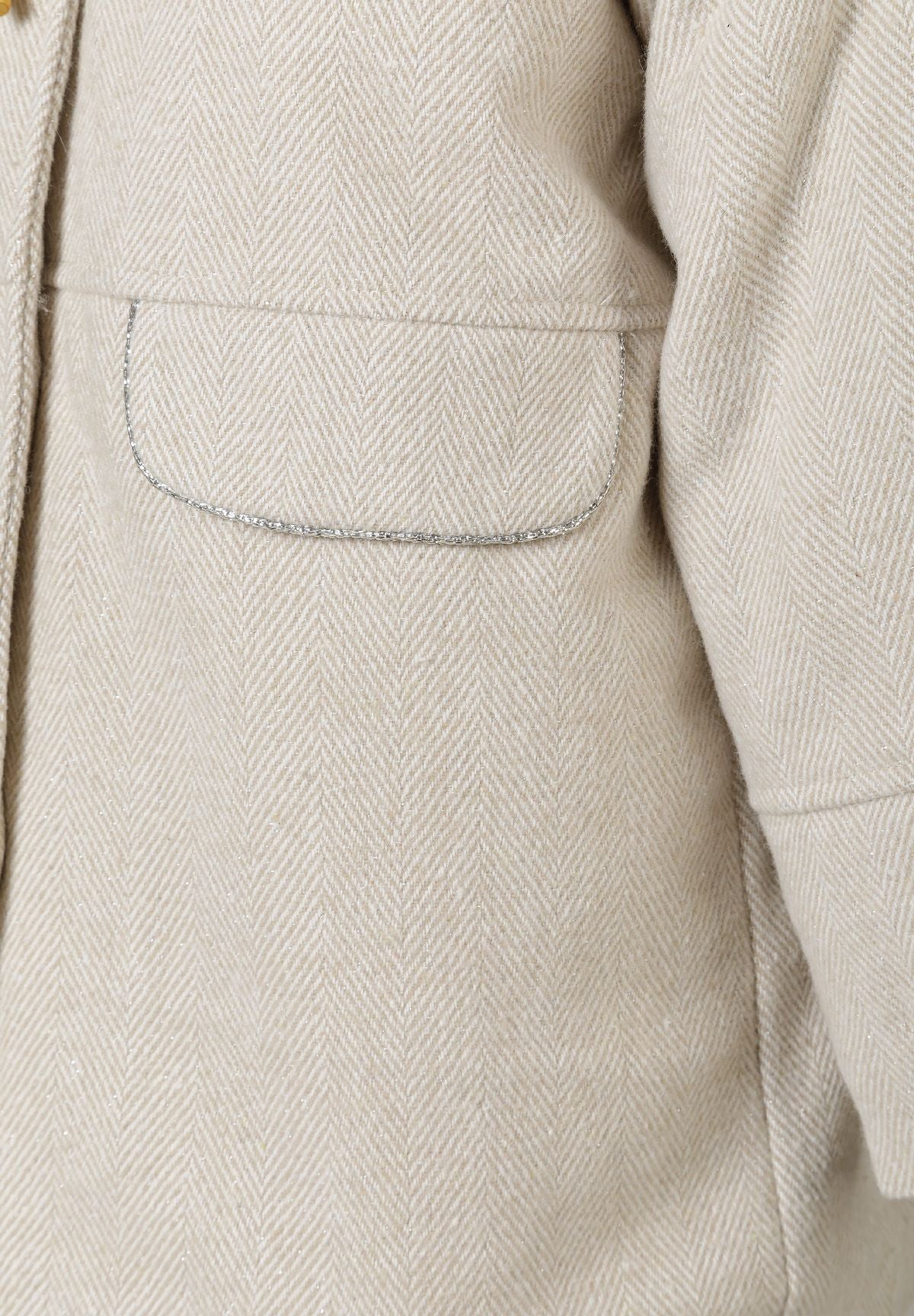 Close-up of the pocket on the light beige duffle coat.