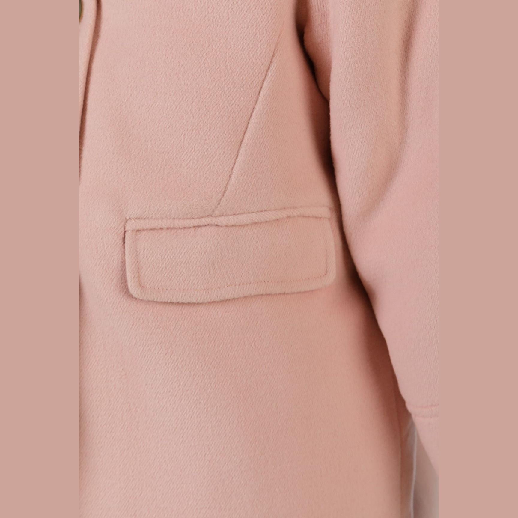 Close-up detail of pink padded coat showing patch pocket construction, fabric texture and stitching quality