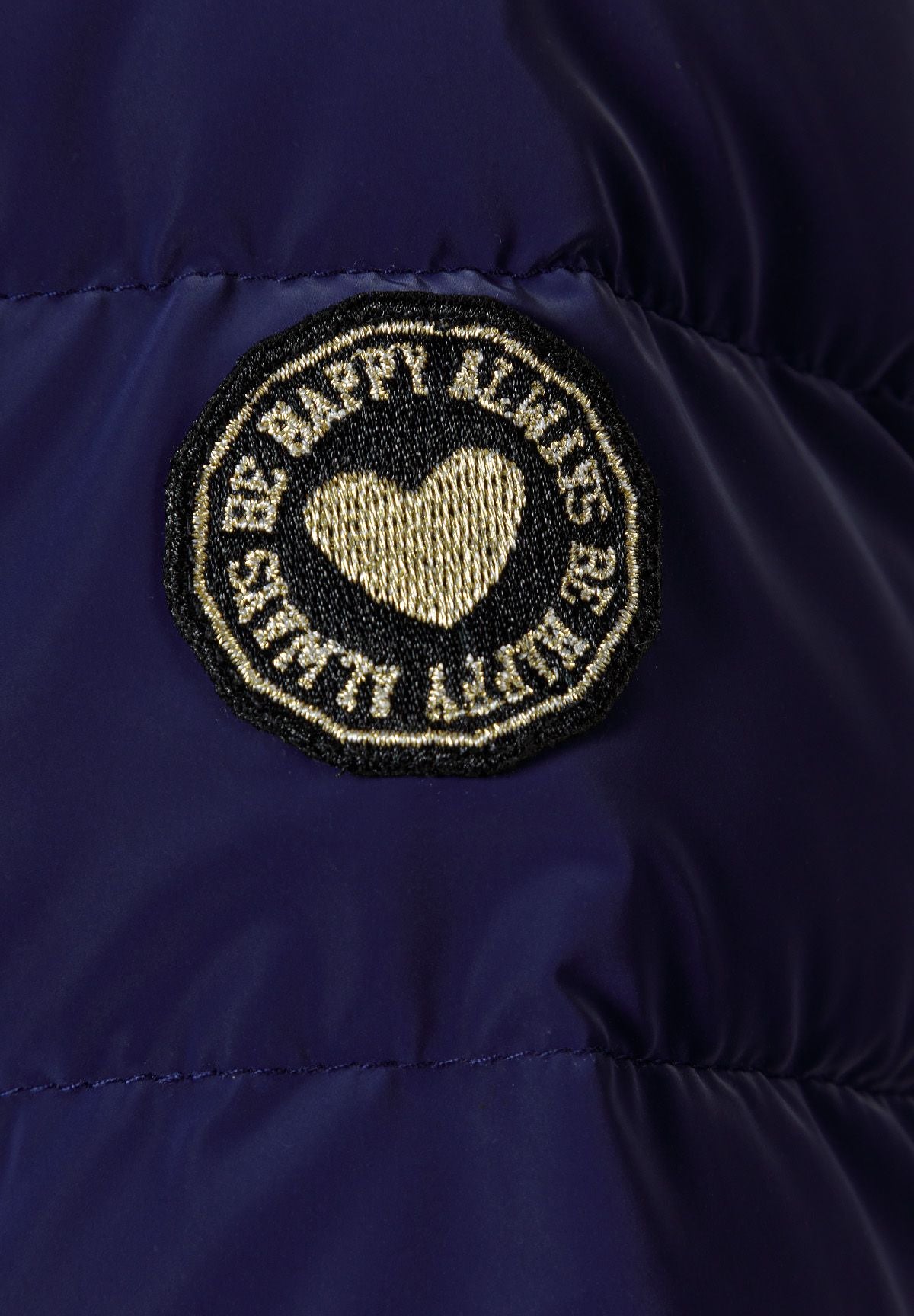 Close-up of the sleeve patch on the navy puffer jacket.