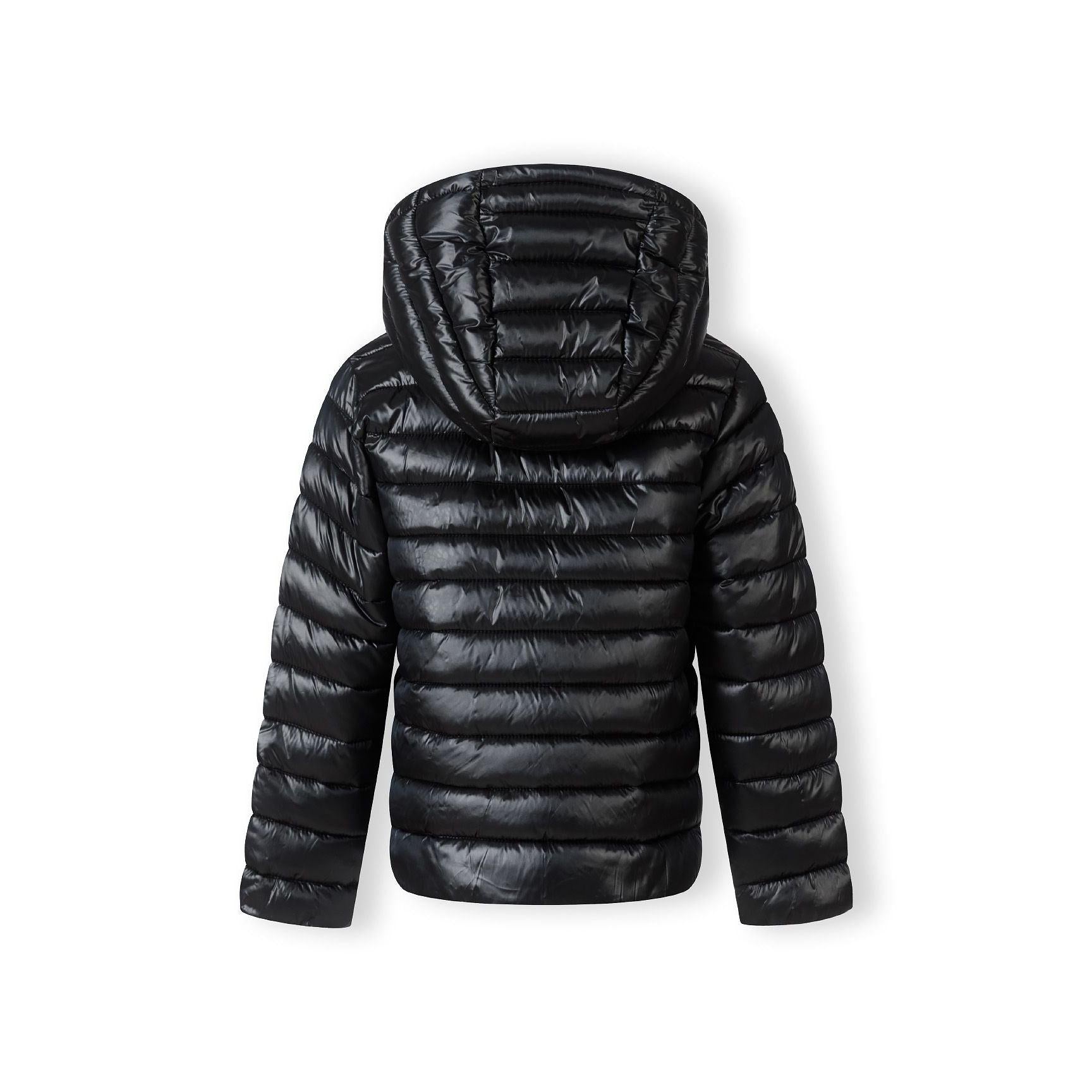 Close-up detail of circular embroidered patch on black quilted jacket sleeve featuring heart design with text around border