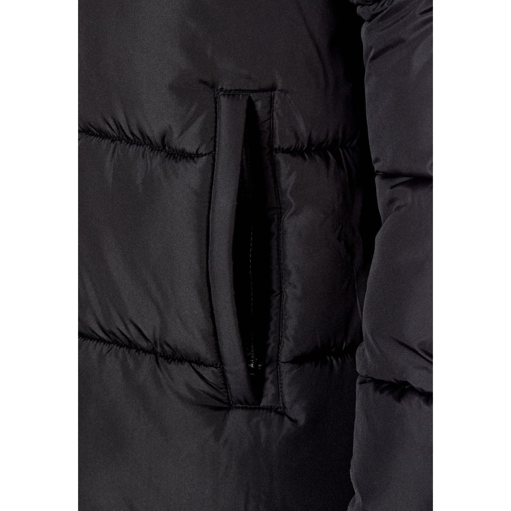 Close-up detail of black quilted parka showing zip pocket construction and padded fabric texture
