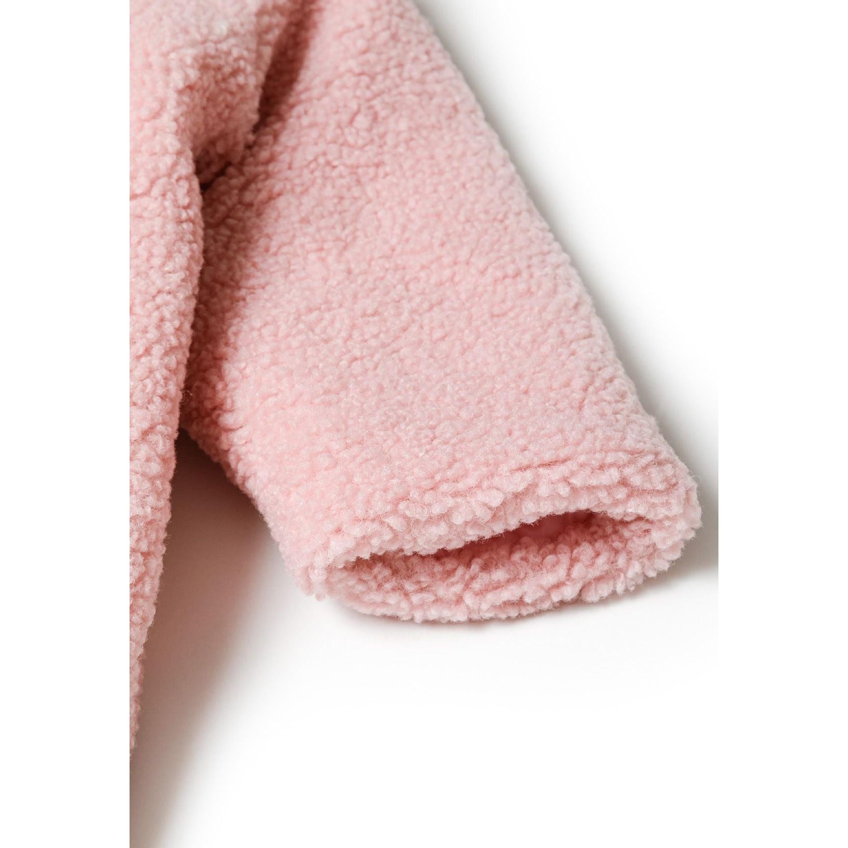 Close-up detail of light pink sherpa snowsuit foot showing textured teddy bear fabric and enclosed toe design