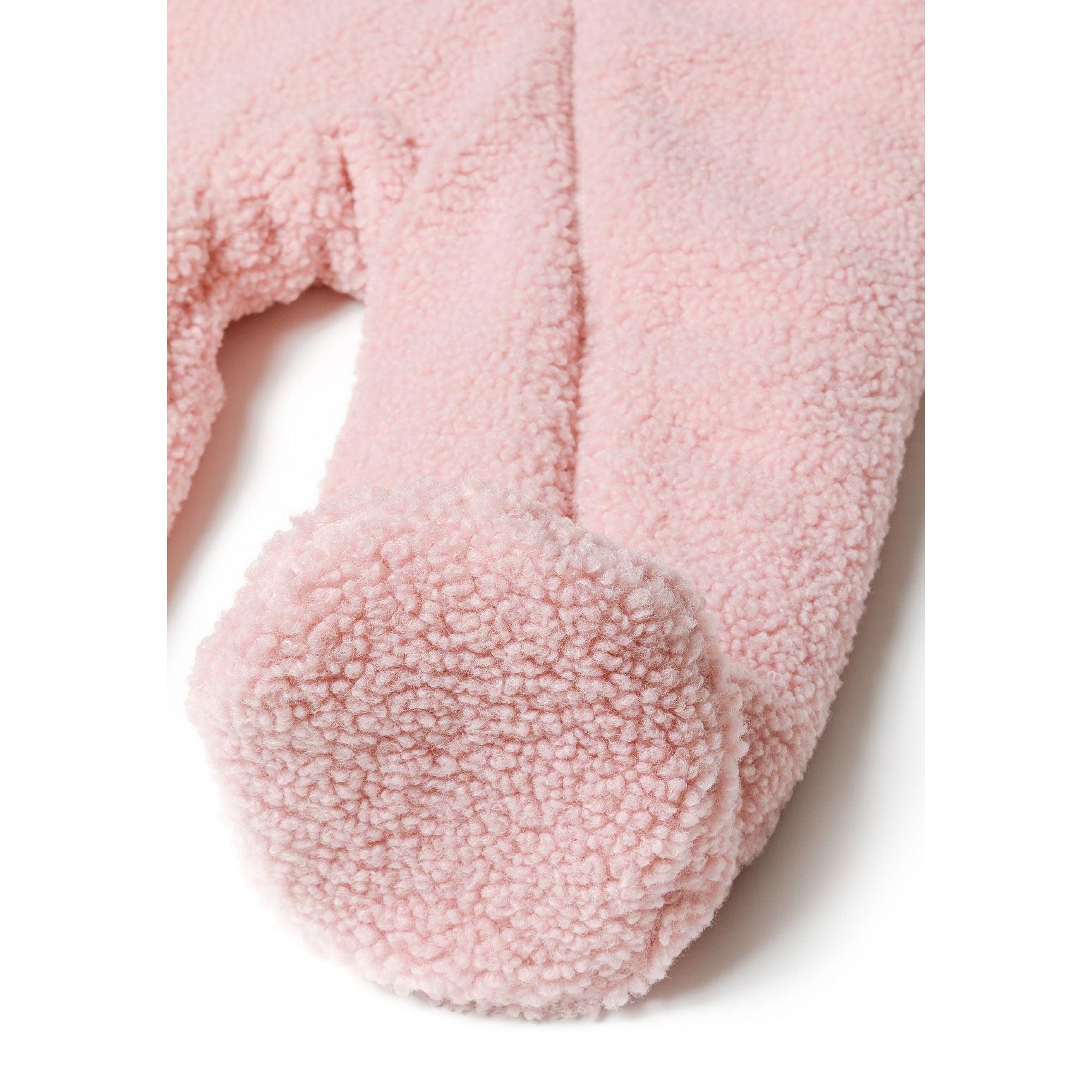 Close-up detail of light pink sherpa snowsuit foot showing textured teddy bear fabric and enclosed toe design