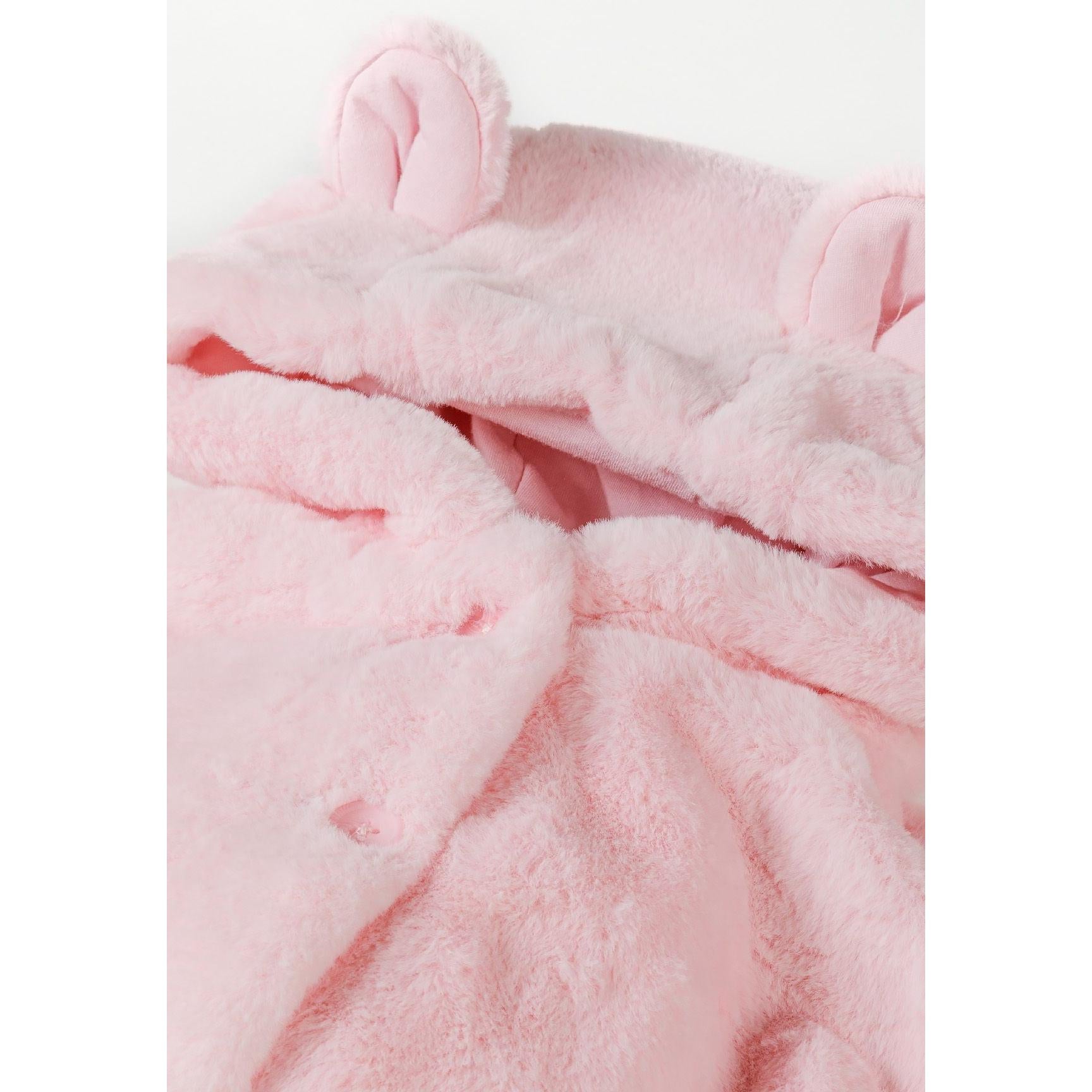 Close-up detail of light pink plush faux fur texture showing soft fuzzy material and construction quality