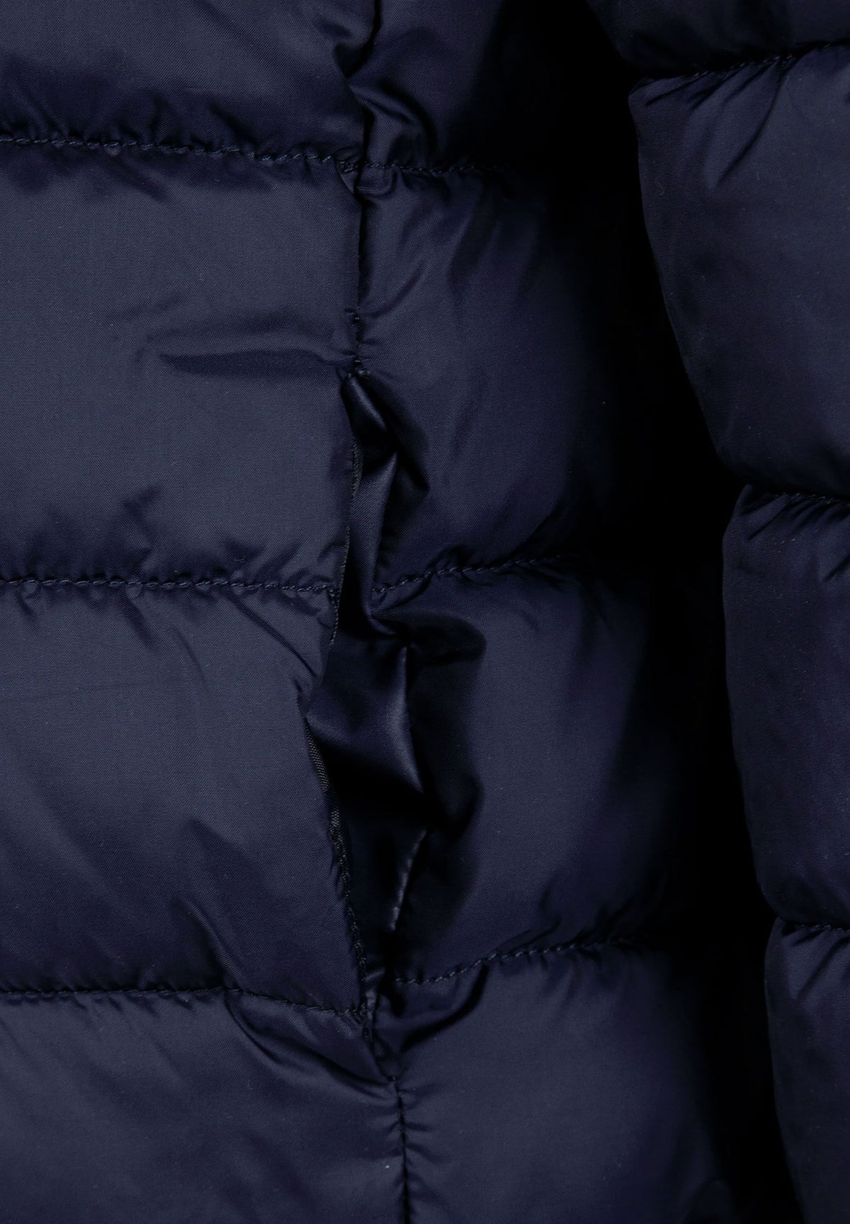 Close-up of the pocket on the navy puffer jacket.