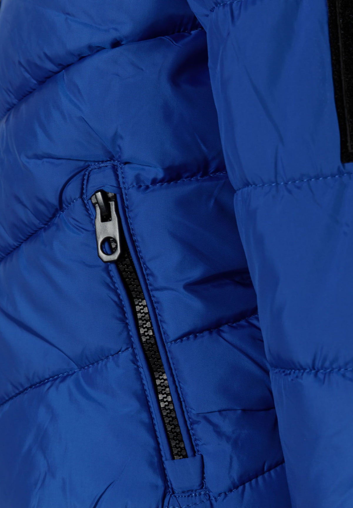 Close-up of the zipped pocket on the blue puffer jacket.