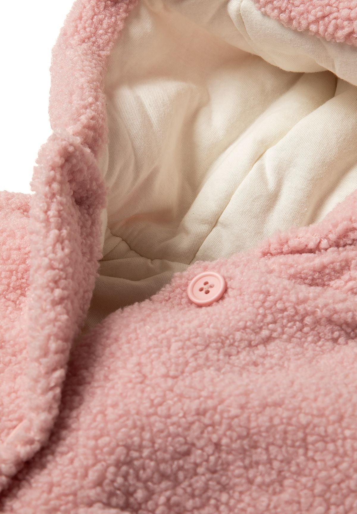 Detail of a light pink teddy baby jacket with hood and button closure.
