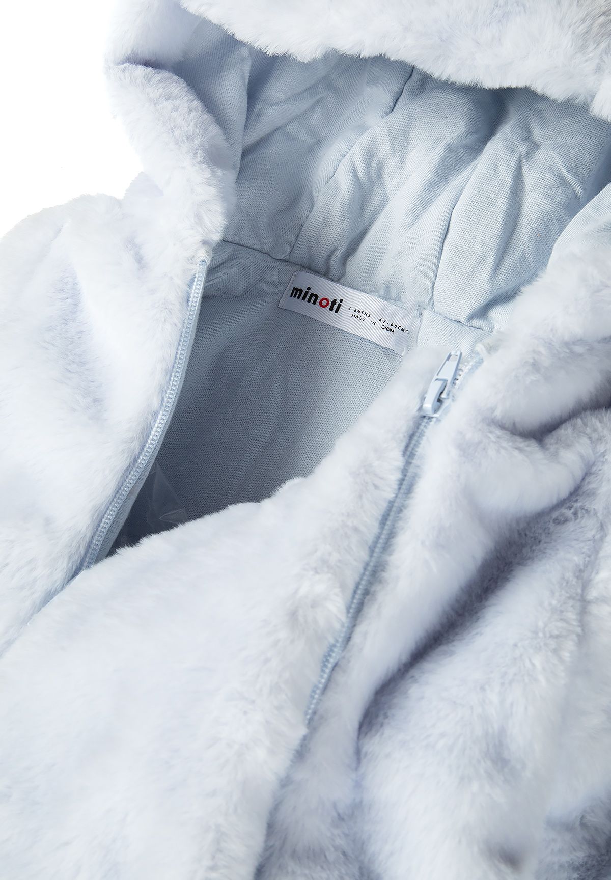 Detail of boys snowsuit with faux fur and hood, featuring a light blue interior.