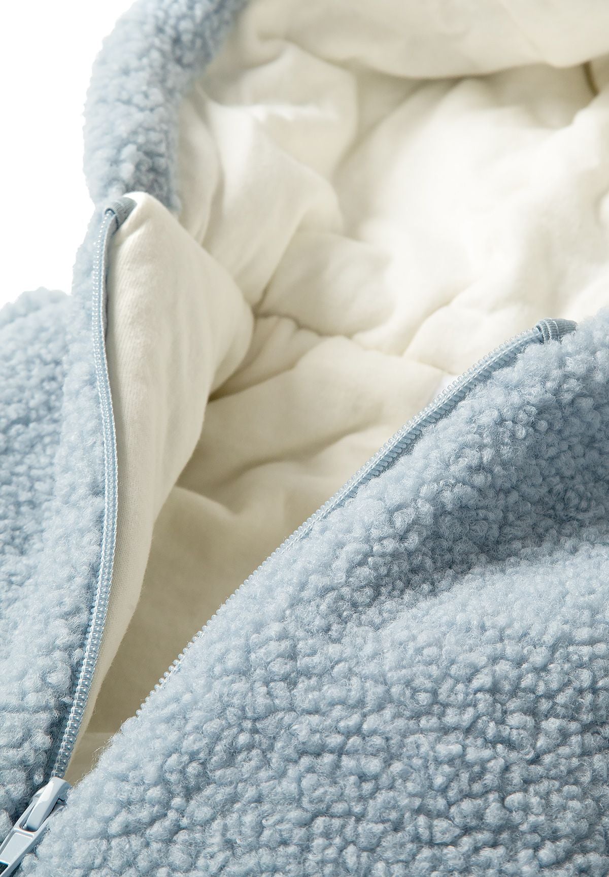 Close-up of a light blue boys snowsuit with sherpa fabric and front zip.
