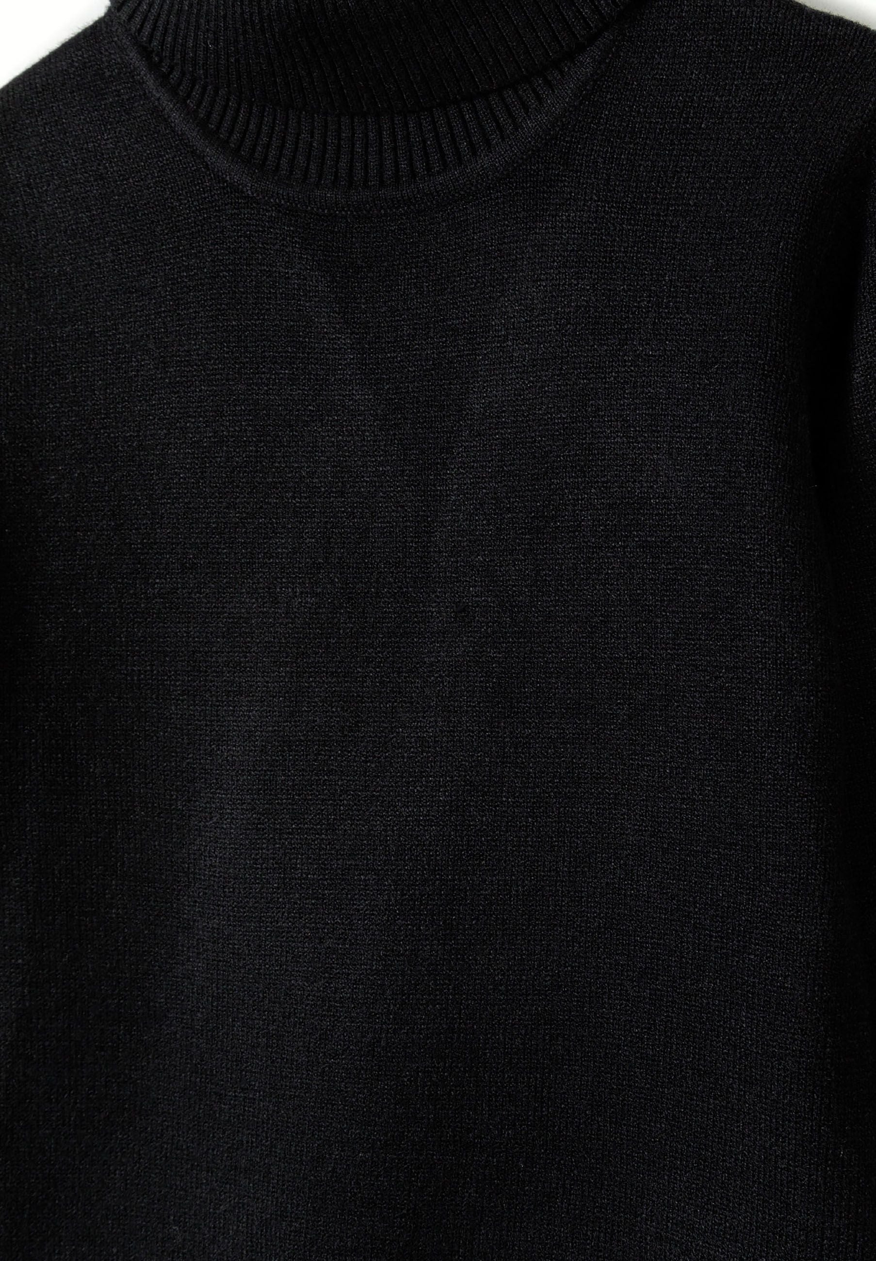 Close-up of a girls' black soft turtleneck jumper with ribbed cuffs.