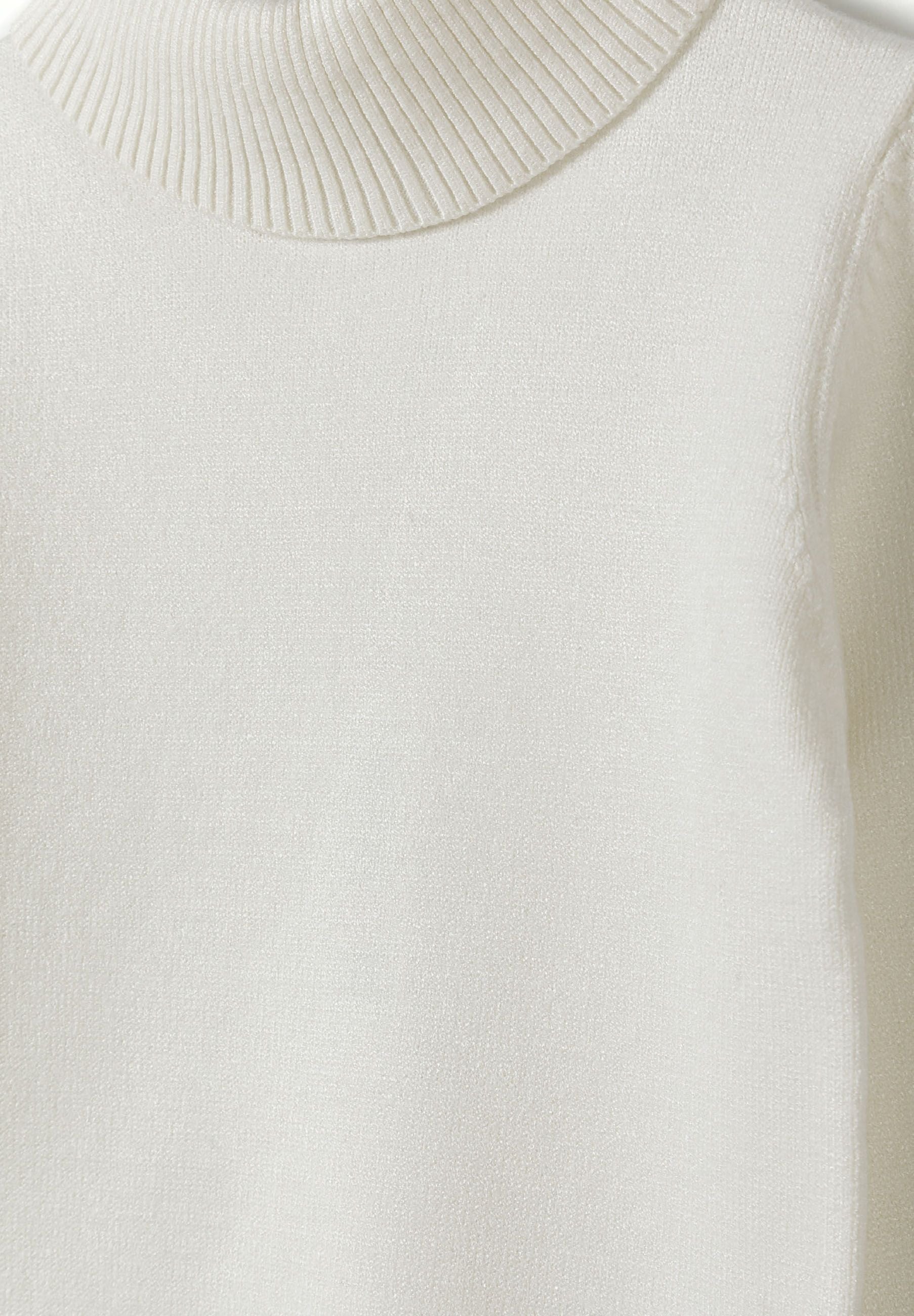 Detail of a girls' cream jumper with a soft turtleneck and ribbed cuffs.
