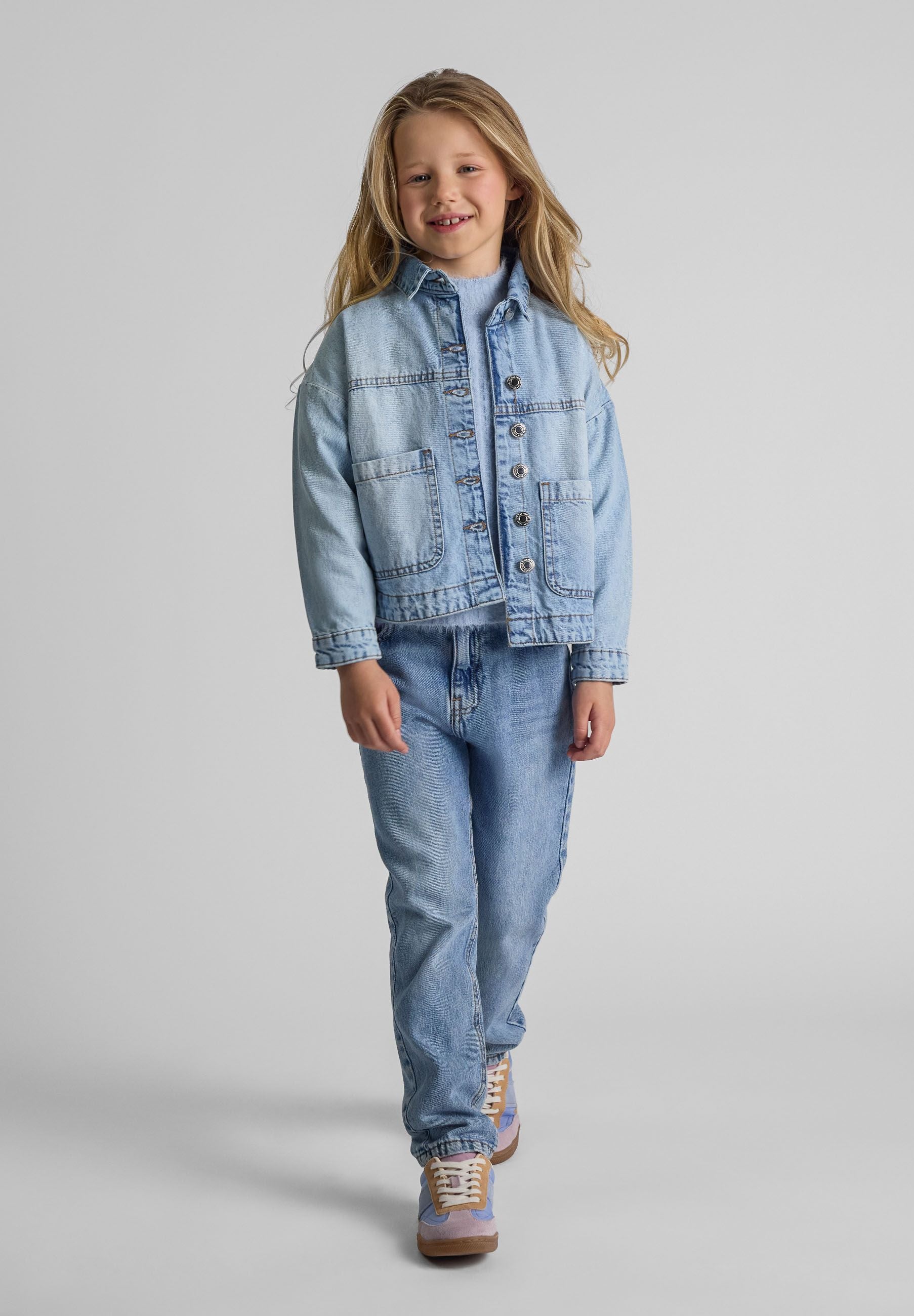 Girls oversized light blue denim jacket, front view with two patch pockets.