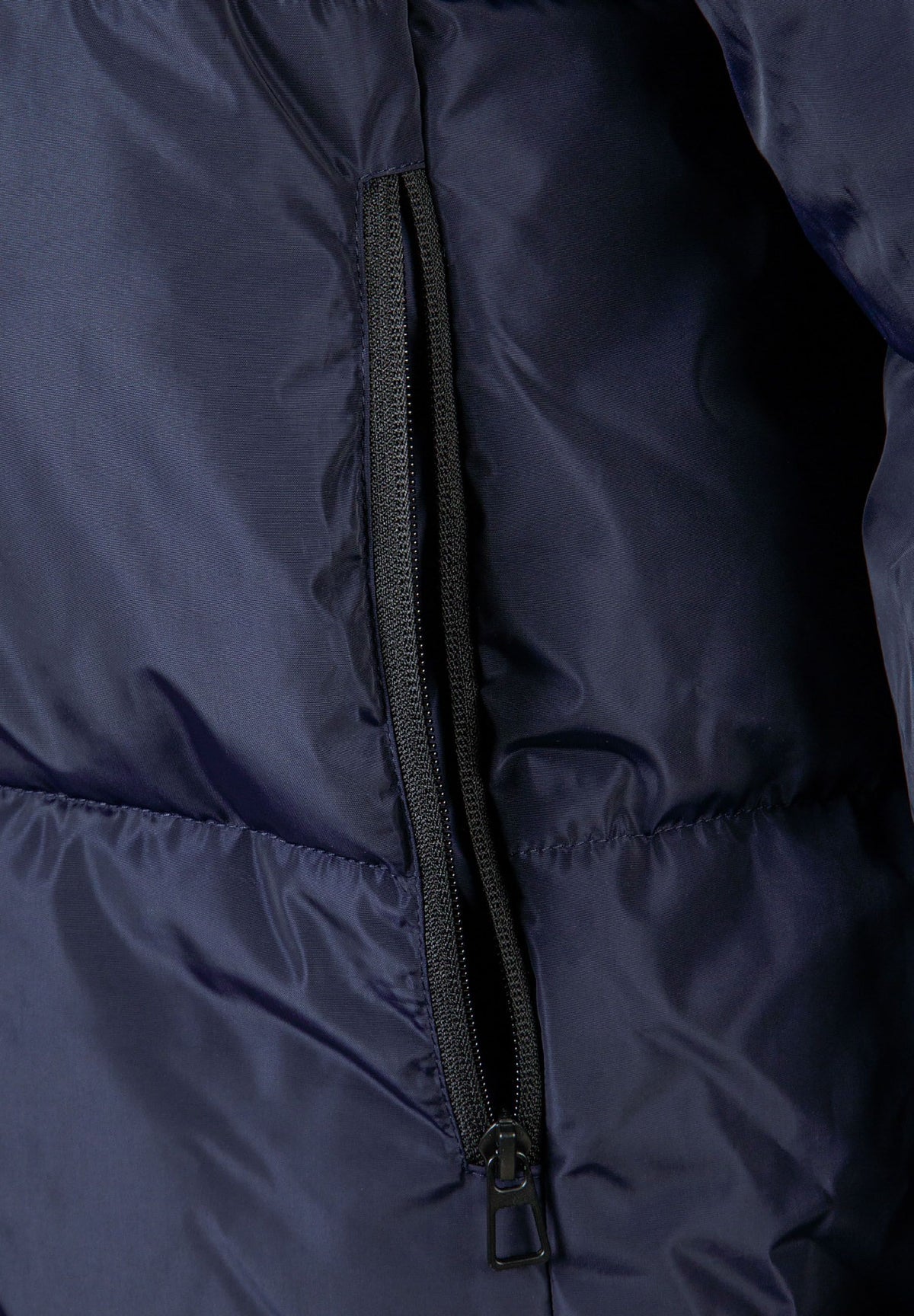 Close-up of the pocket on the navy long puffer coat.