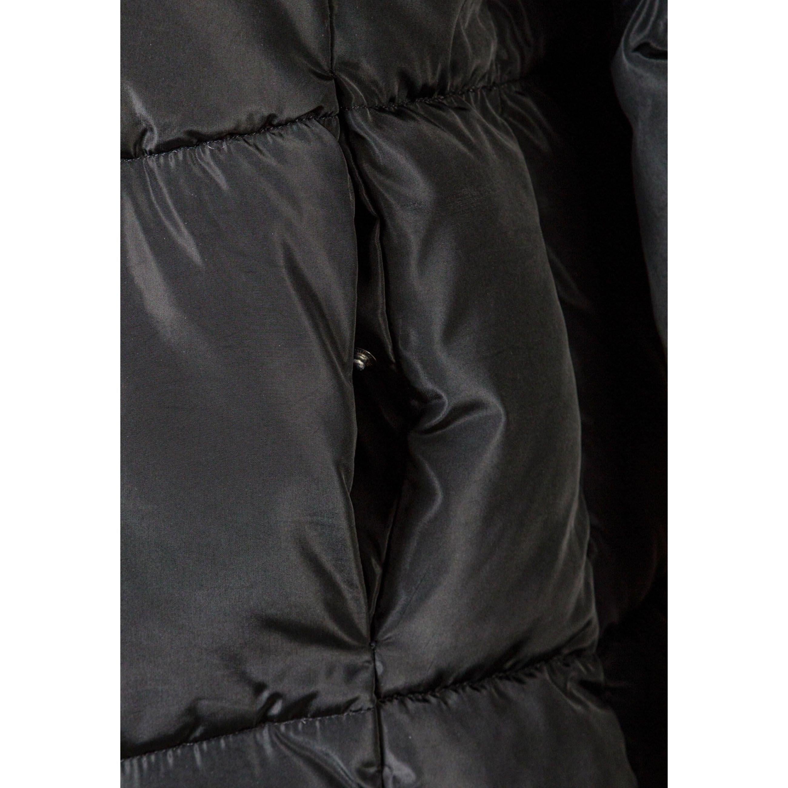 Close-up detail of black quilted fabric texture showing chevron stitching pattern