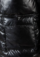 Detail of a black quilted women's jacket showing a flap pocket.