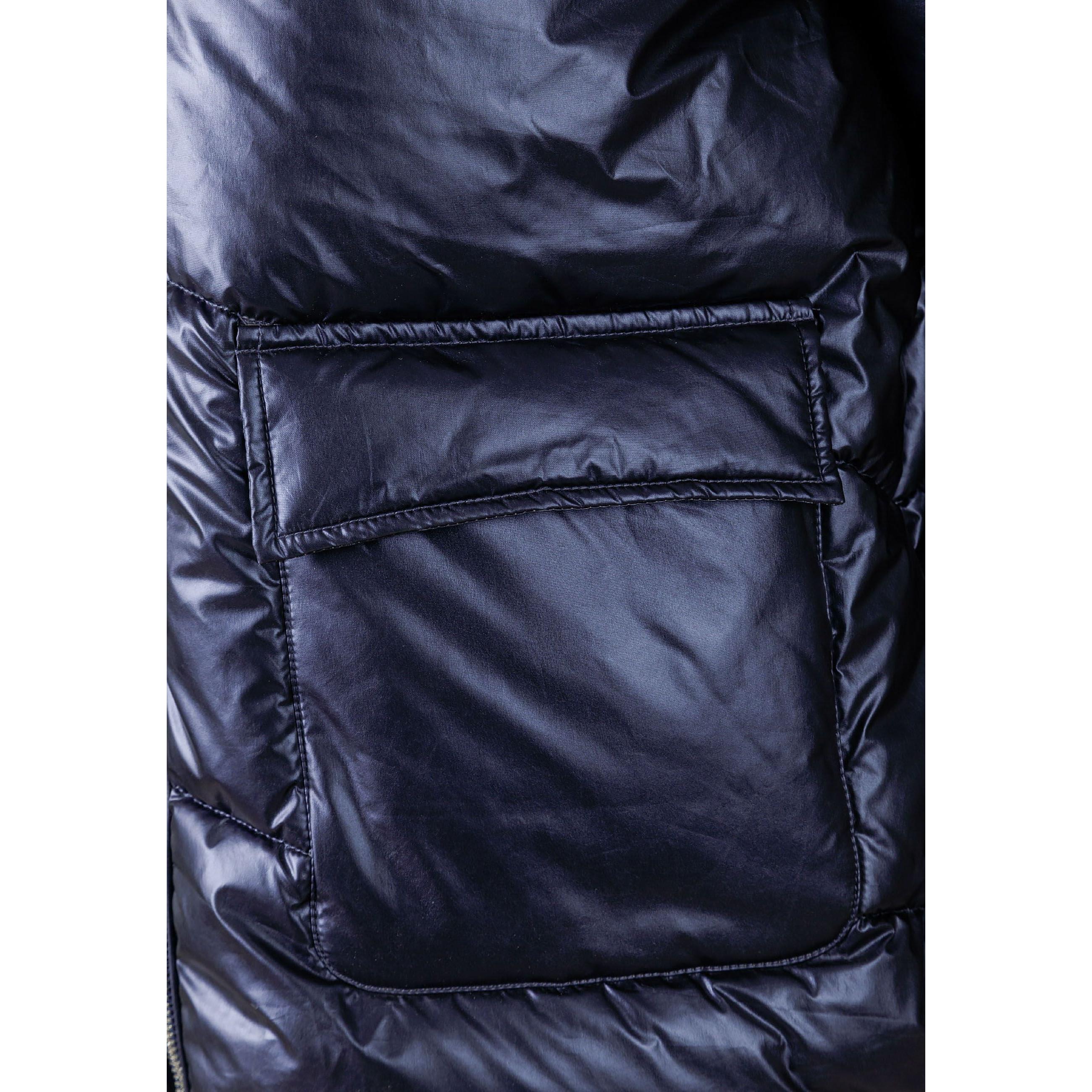 Close-up detail of navy quilted puffer jacket showing padded panels, stitching construction and fabric texture