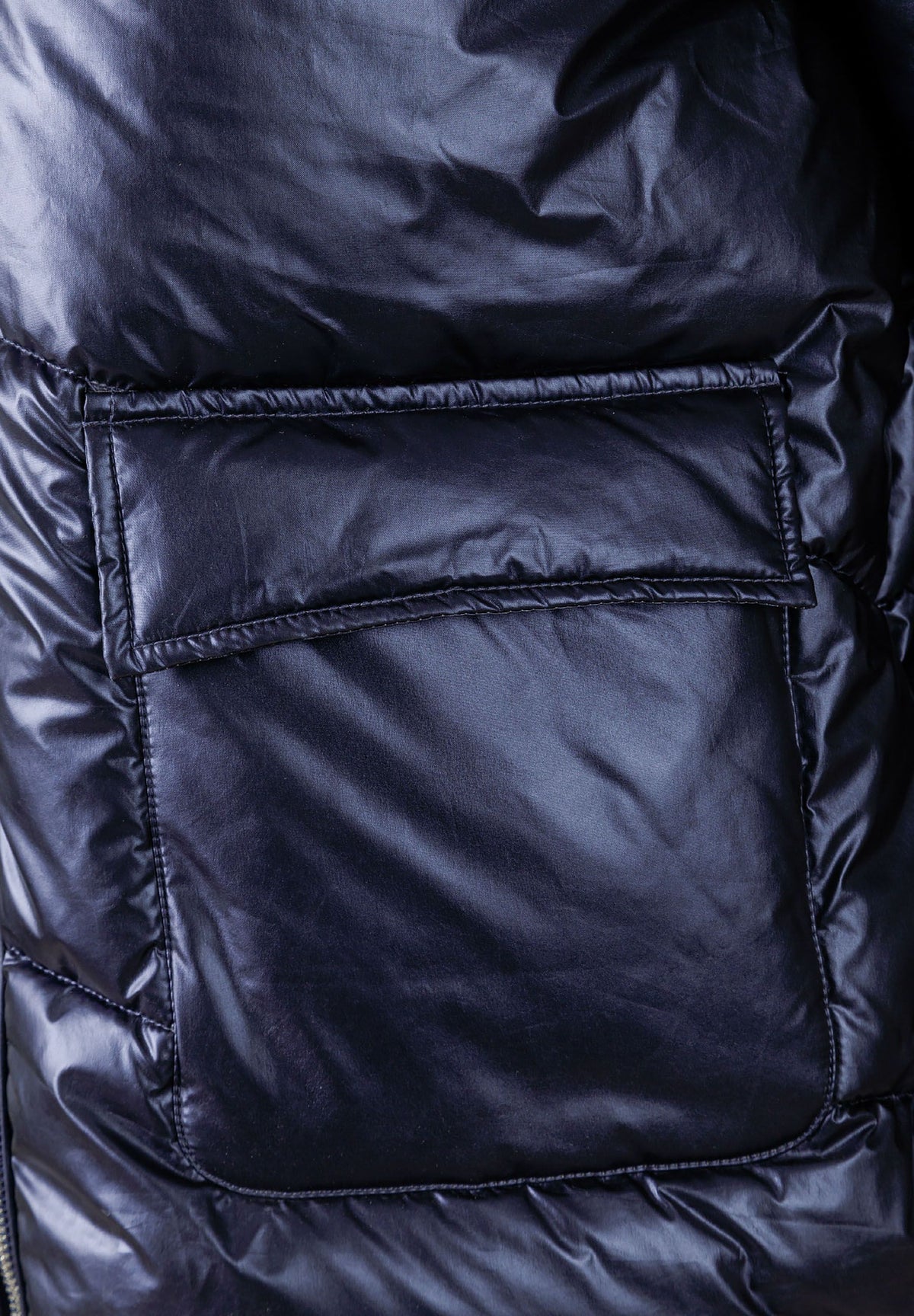 Close-up of the pocket on the navy puffer jacket.