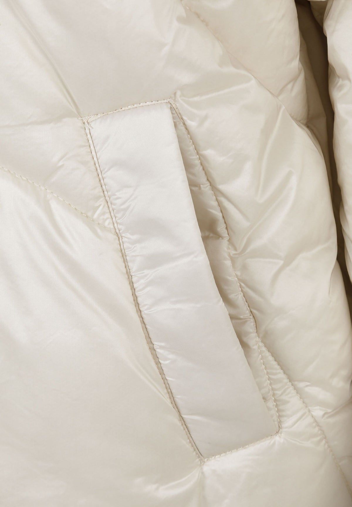 Close-up of the pocket on the cream puffer jacket.