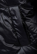 Detail of a black insulated women's jacket showing curved stitching and pocket opening.