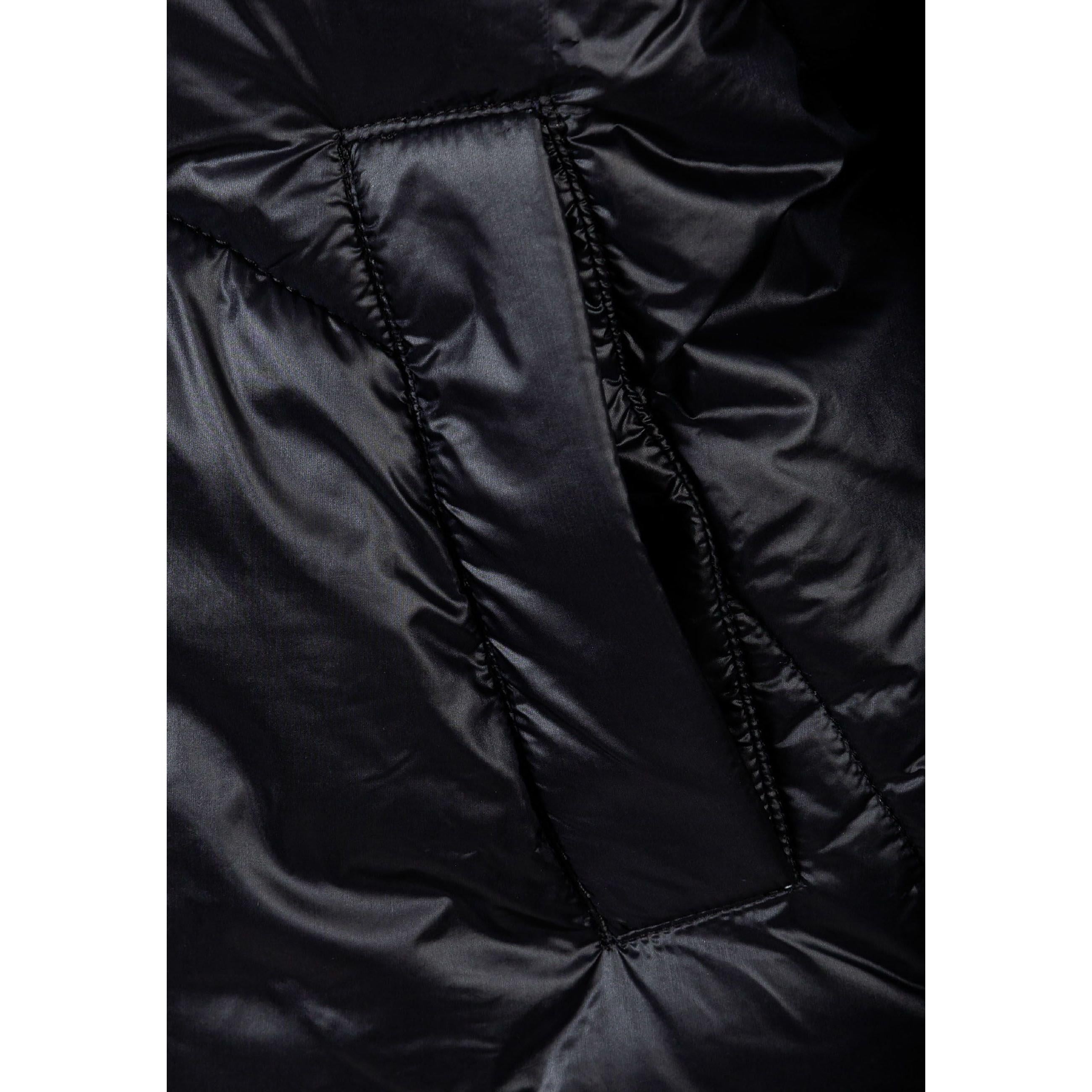 Close-up detail of black quilted jacket fabric showing glossy finish and horizontal stitching lines