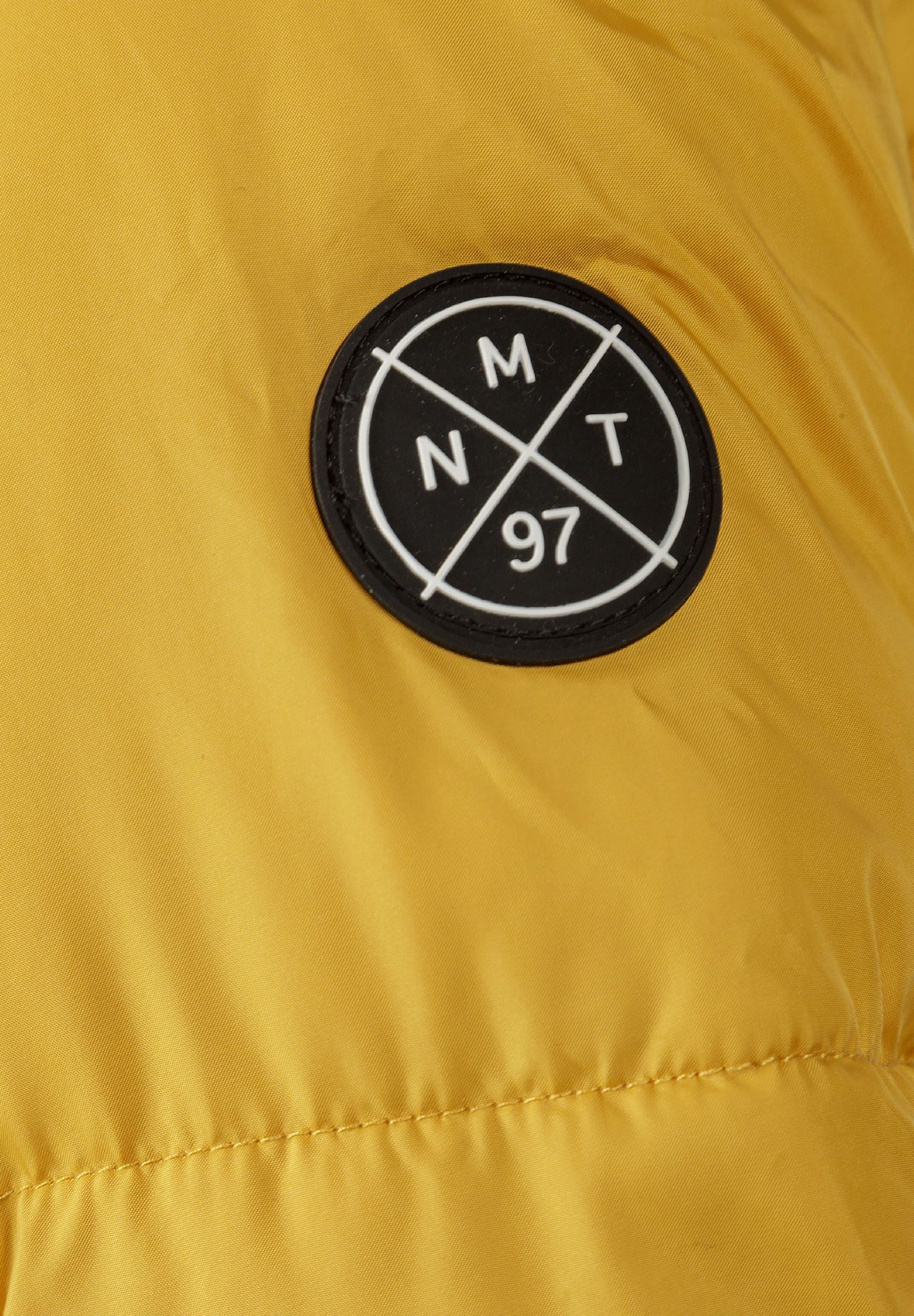Detail of mustard teddy lined jacket with logo badge.