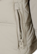Detail of a boys quilted jacket showing a zippered pocket in grey.