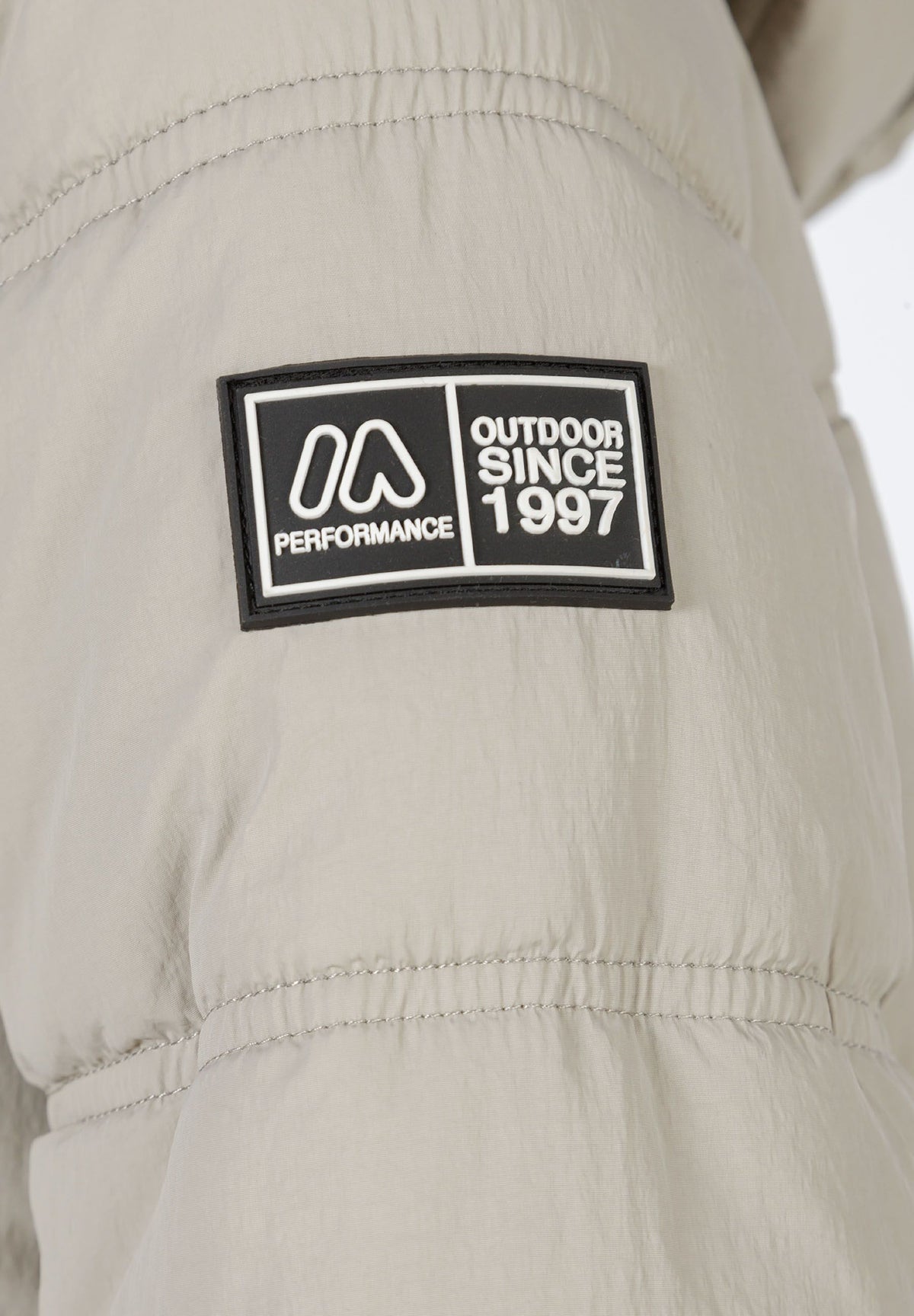 Close-up of the sleeve badge on the stone puffer jacket.