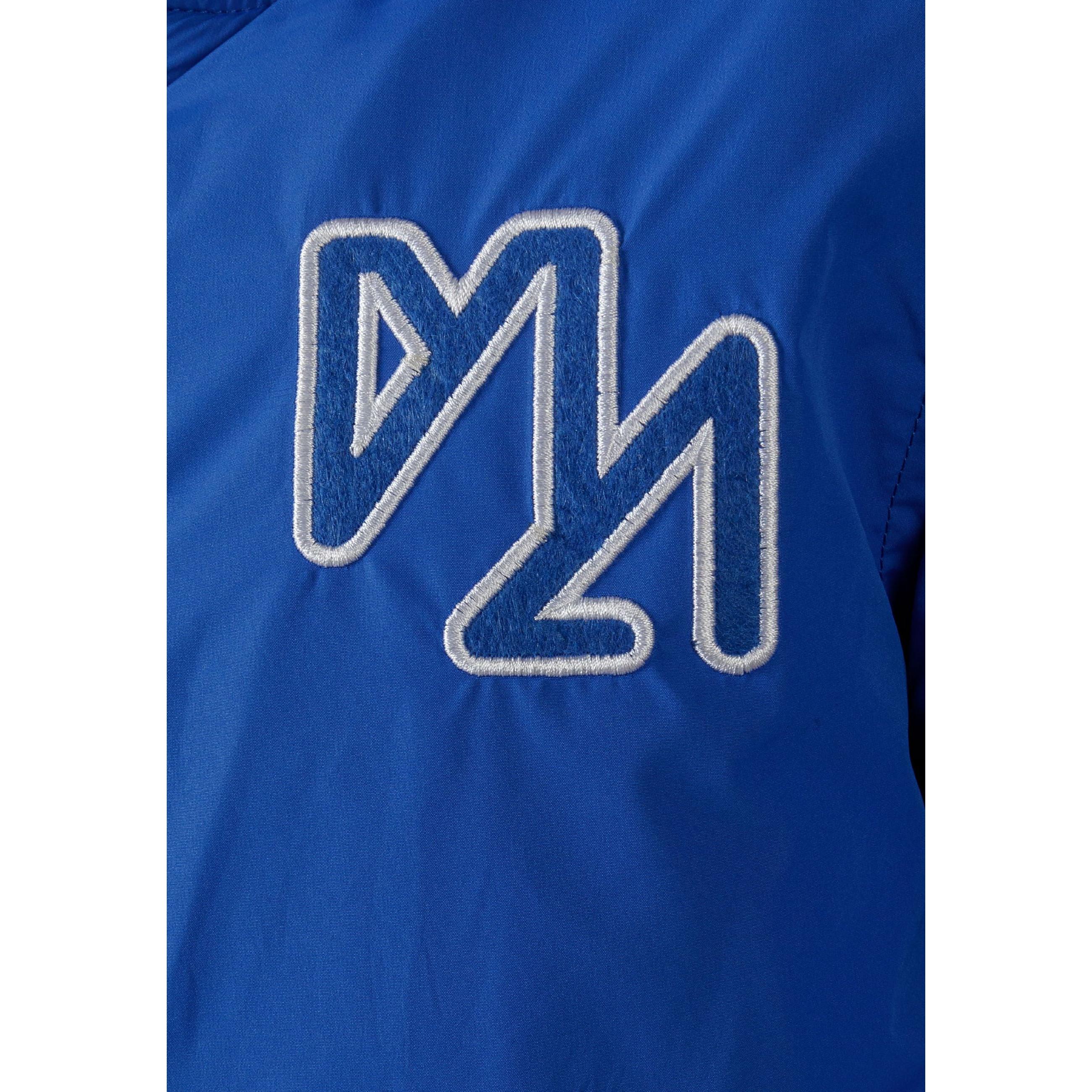 Close-up detail of white embroidered M logo on cobalt blue baseball jacket fabric
