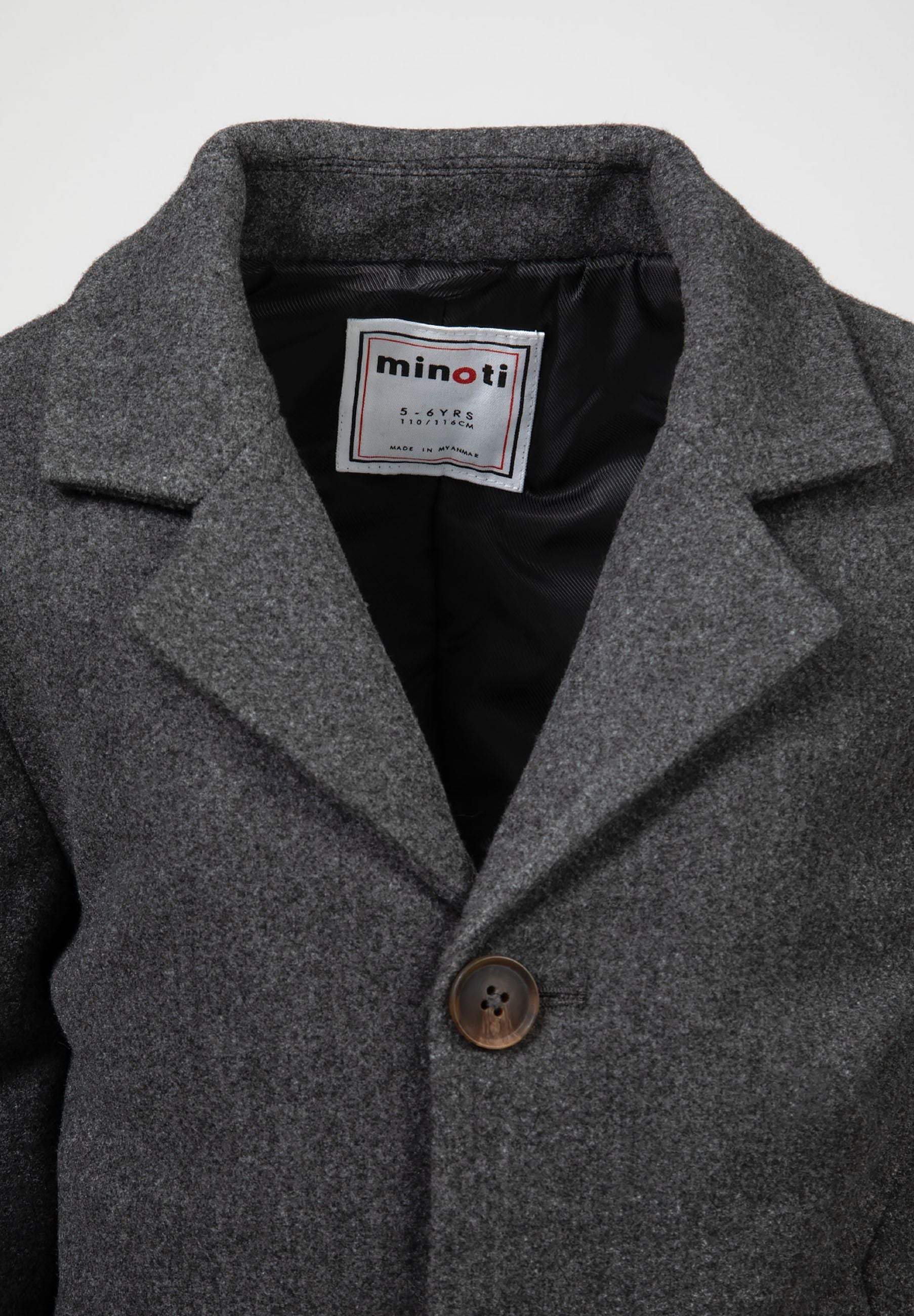 Close-up of a boys' grey smart coat with a structured collar and mock horn button.