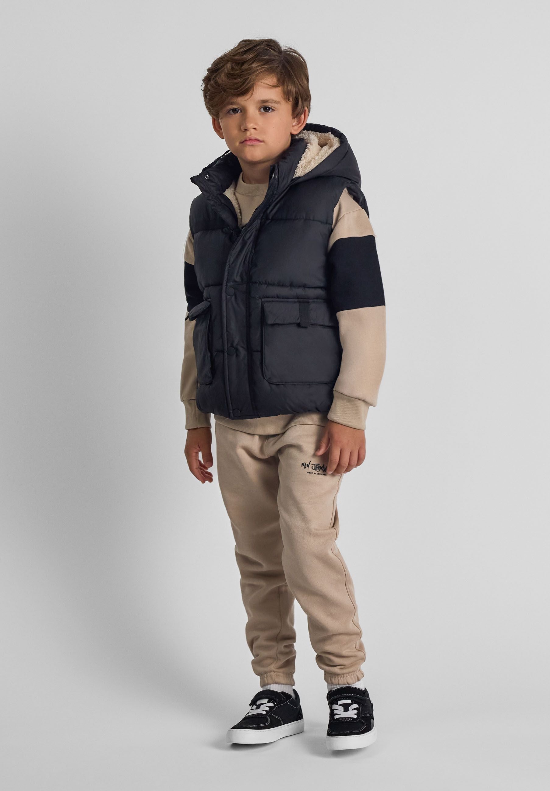 Boys black gilet with hood, front view, featuring two snap-button pockets.