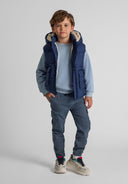 Boys navy gilet with hood, snap pockets, and high collar, front view.