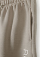 Detail of joggers with elastic waistband and side pocket, featuring 'FUTURE' print.