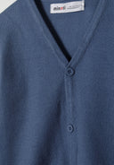 Close-up of a blue boys cardigan with button fastening and v-neckline.