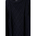 Close-up detail of navy cable knit jumper showing intricate raised diamond texture pattern and crew neck collar construction