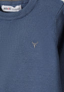 Close-up of a blue boys' fine knit jumper with embroidered logo on the chest.