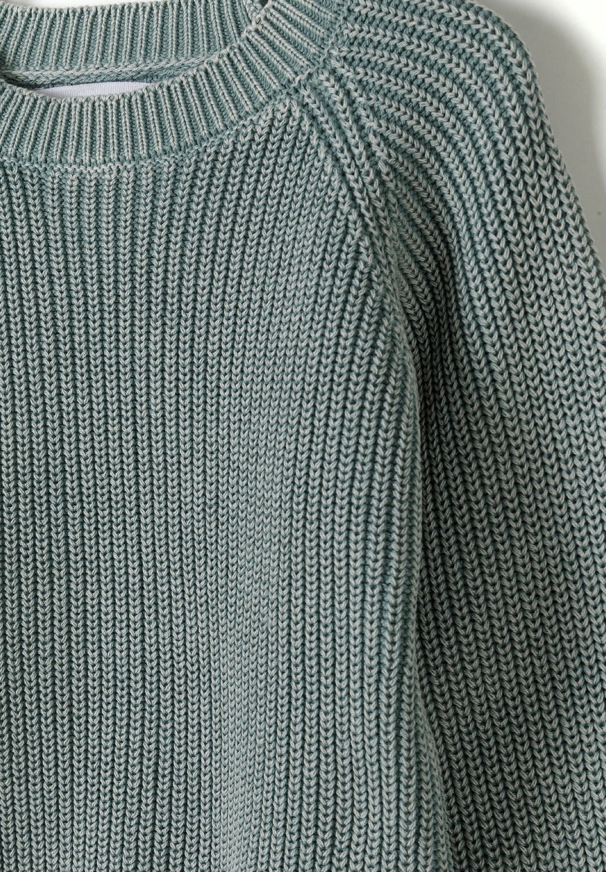 Sage green ribbed jumper, knit and neckline detail.