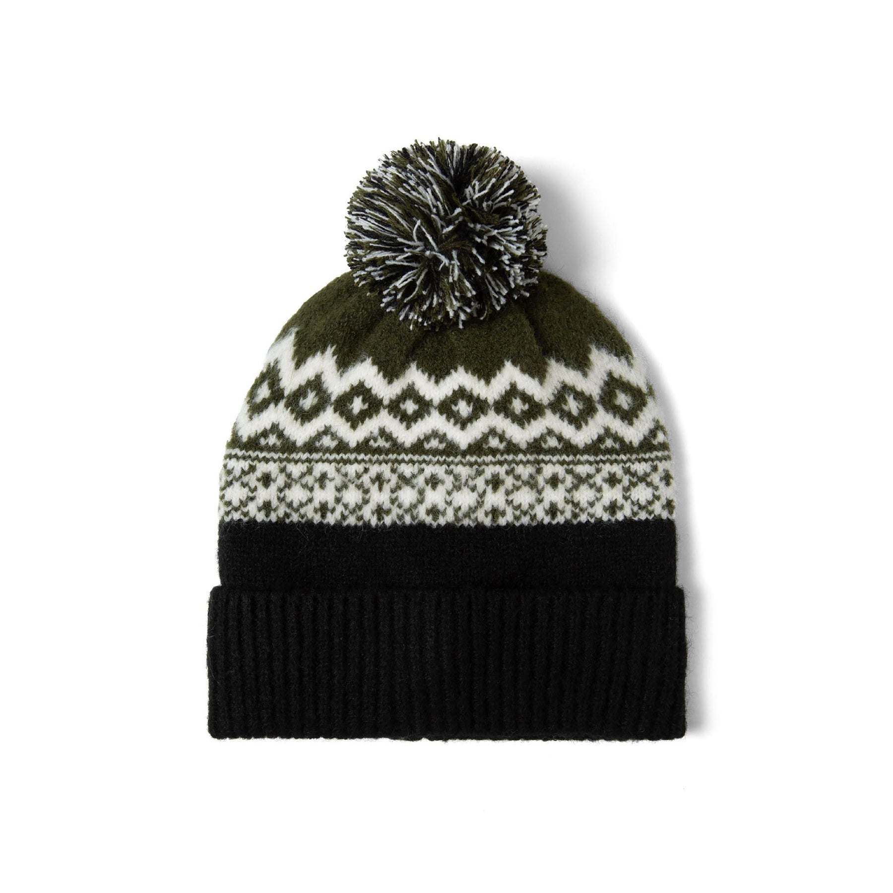 Close-up detail of black and cream fair isle knit pattern on hat with textured pom pom showing diamond and geometric designs