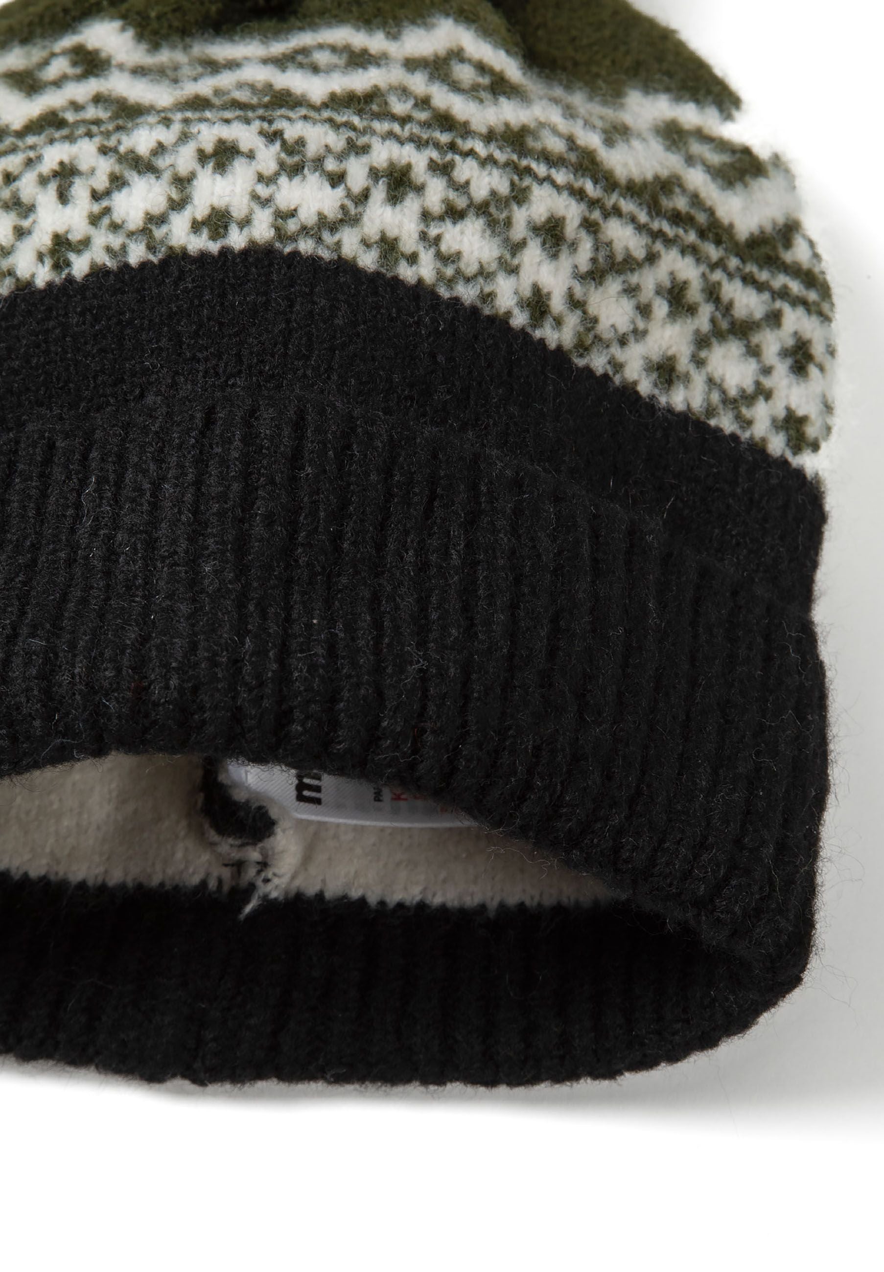 Close-up of a black knit hat with a fair isle pattern and a turn-up cuff.
