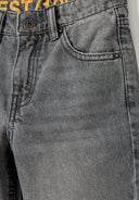 Detail of grey boys denim jeans with rip-and-repair detailing and front pocket.