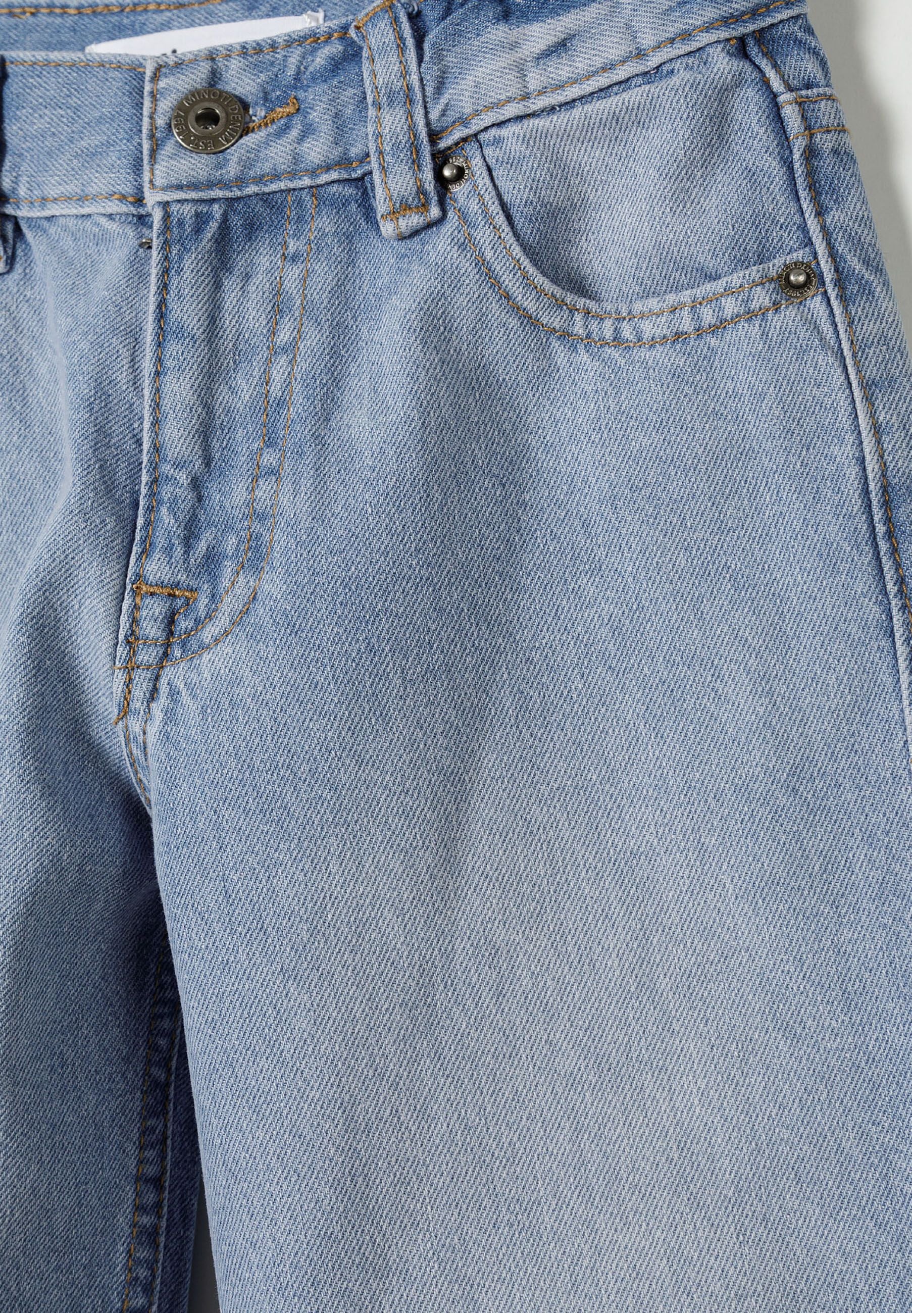 Detail of boys baggy fit denim jeans in light blue with five-pocket design.