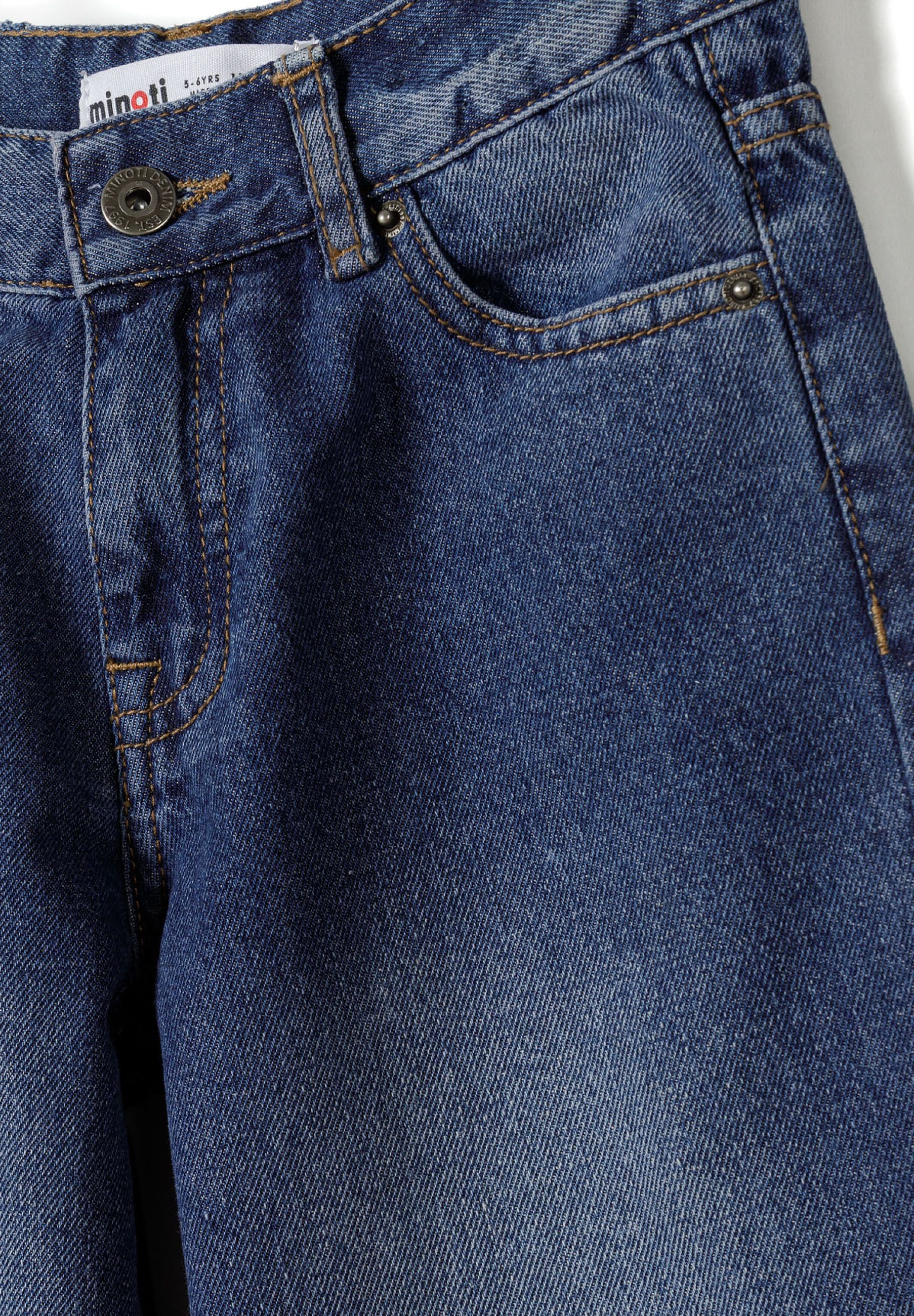 Close-up of boys baggy fit denim jeans in navy with zip front and five-pocket design.