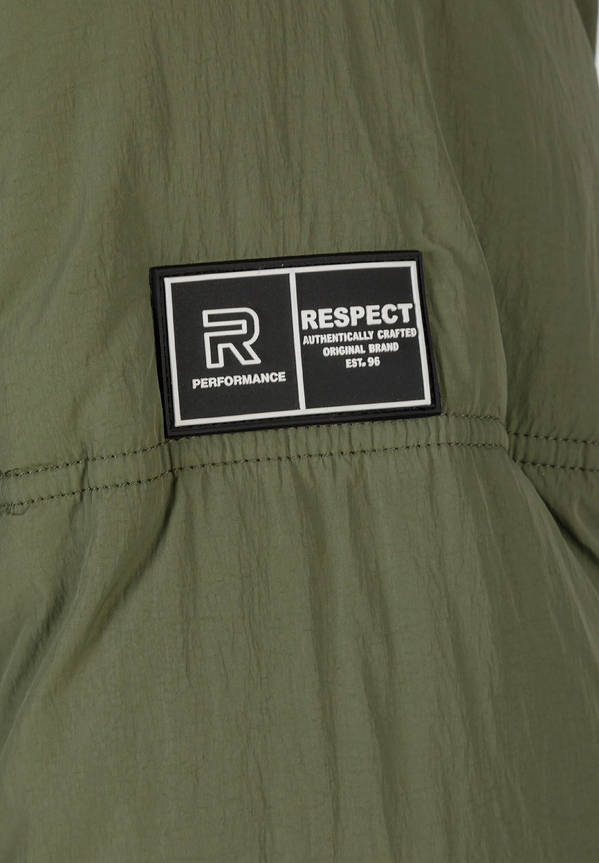 Close-up of the sleeve patch on the khaki puffer jacket.