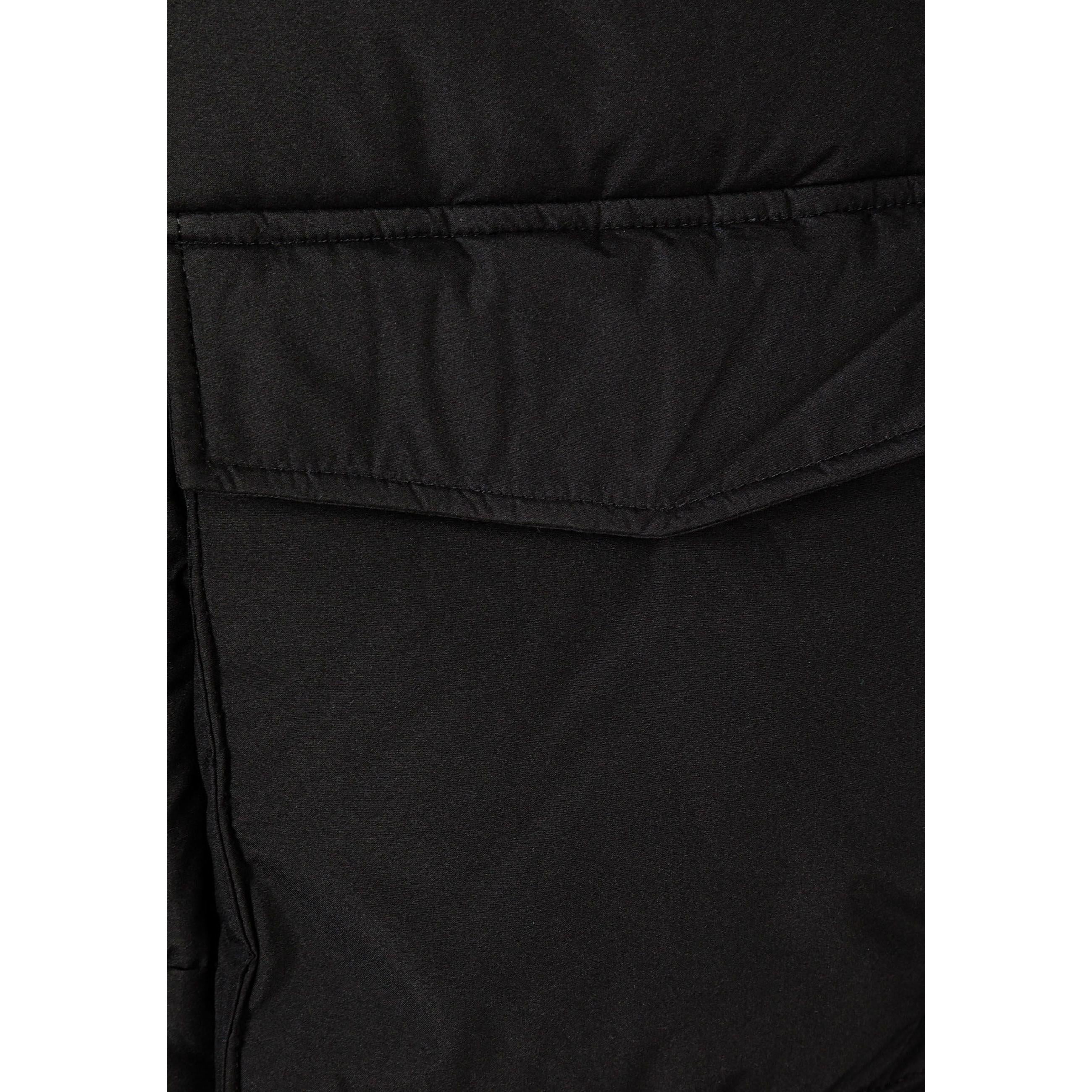 Close-up detail of black parka jacket showing hexagonal logo patch on quilted fabric