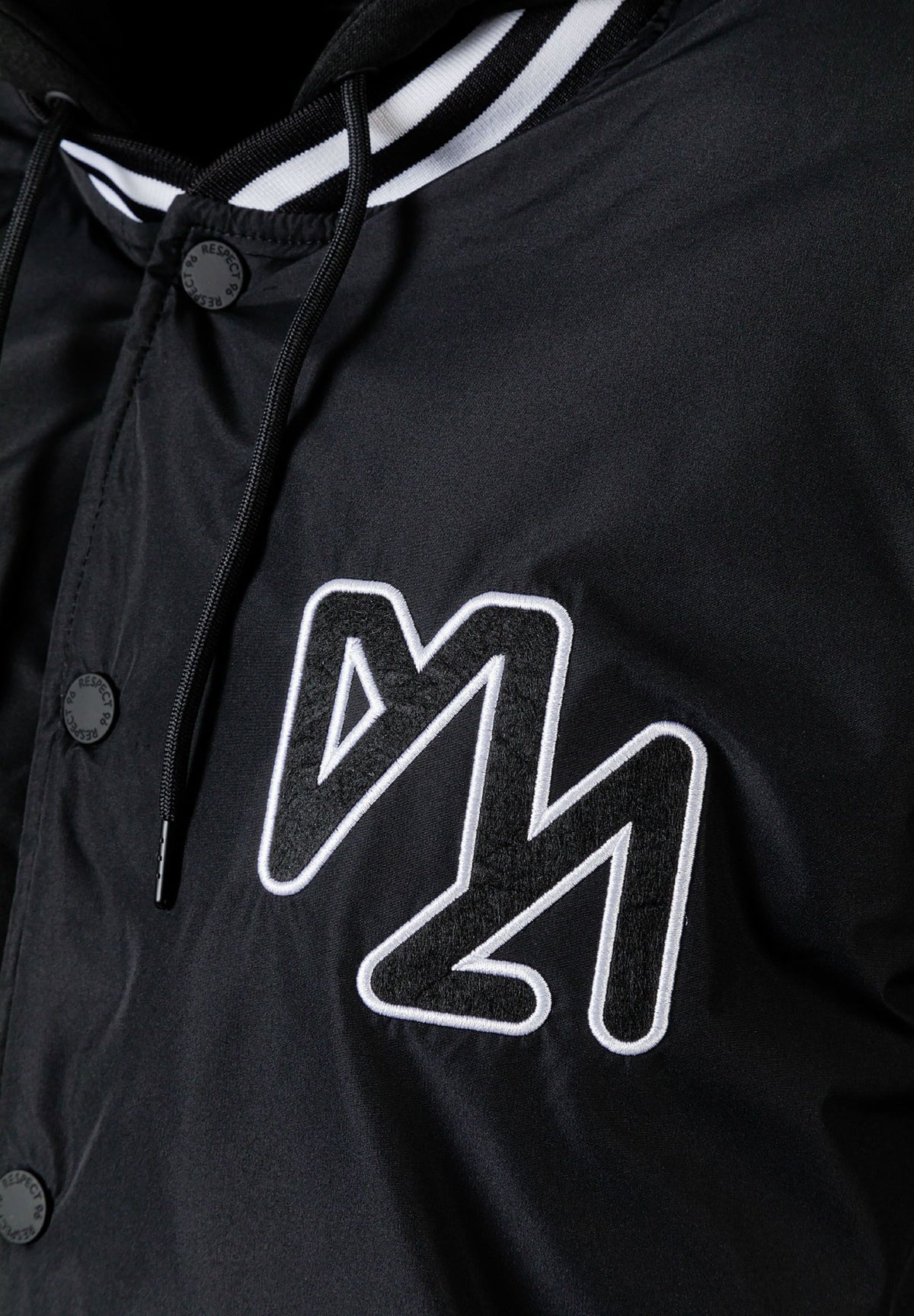 Close-up of the chest on the black varsity jacket.