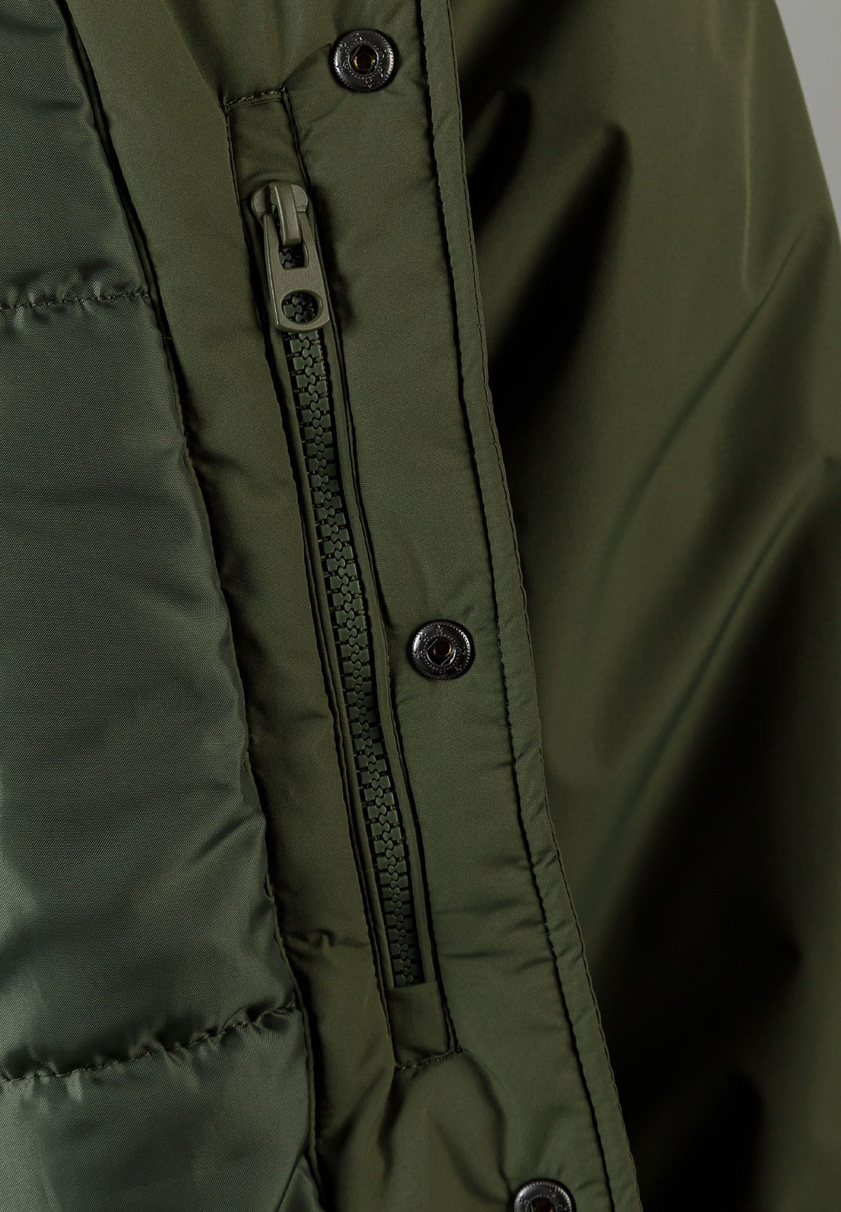 Close-up of the inside pocket on the khaki varsity jacket.