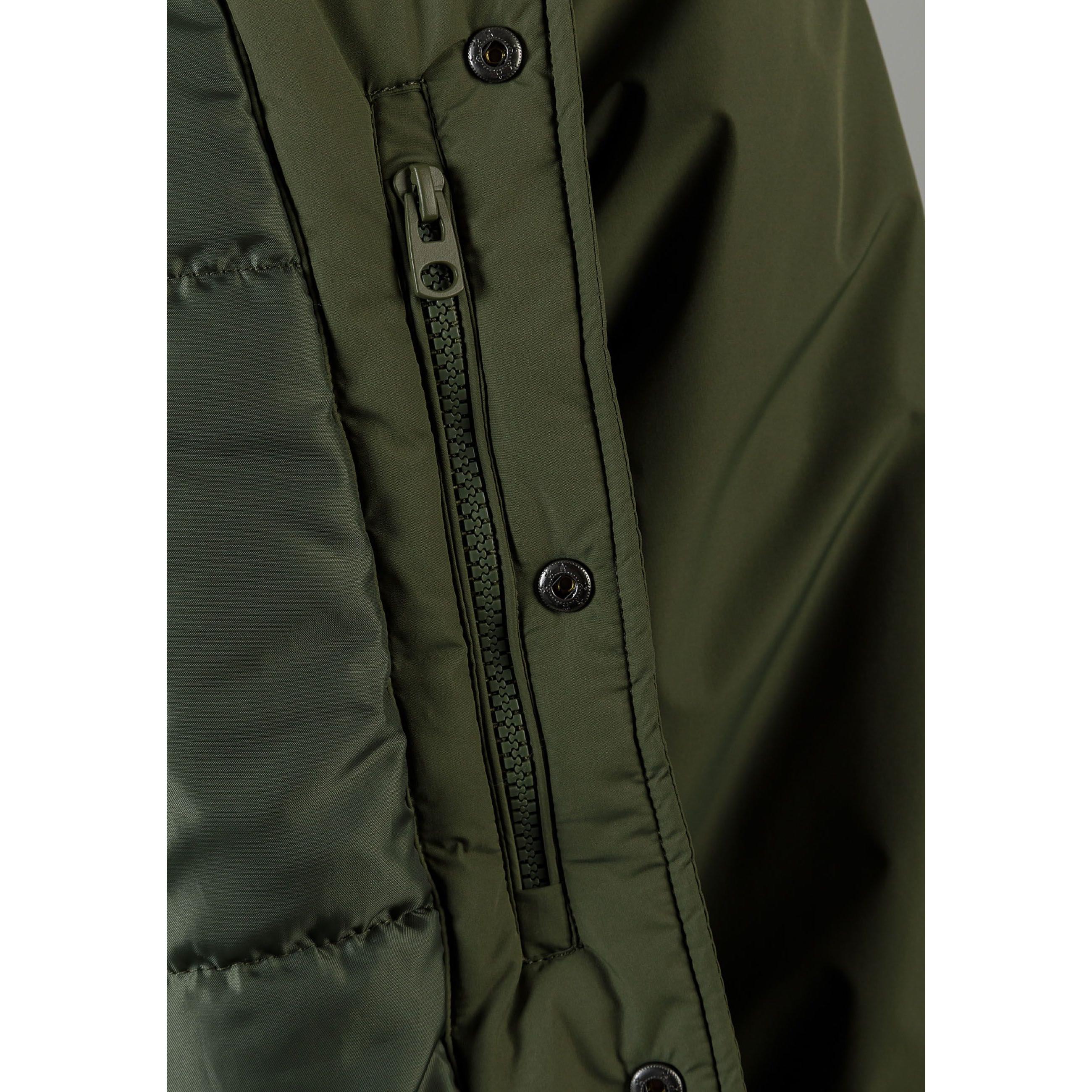 Close-up detail of khaki jacket showing zip pocket, button closure and ribbed trim construction